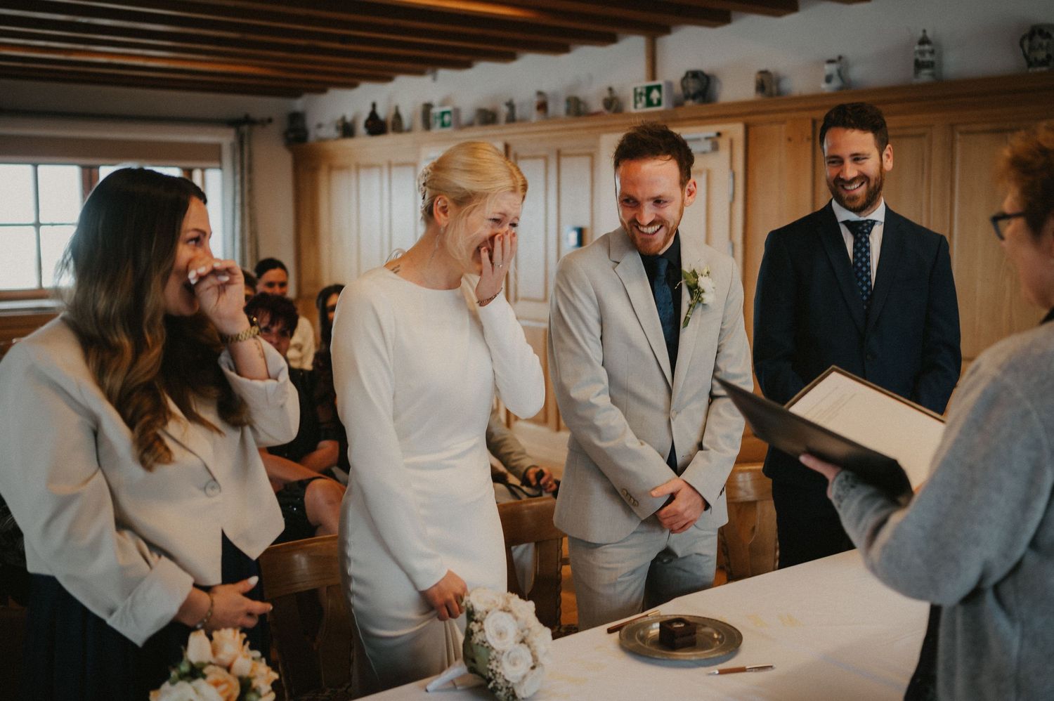 Wedding celebration candid moments captured in a warm-lit venue with wooden interior details.