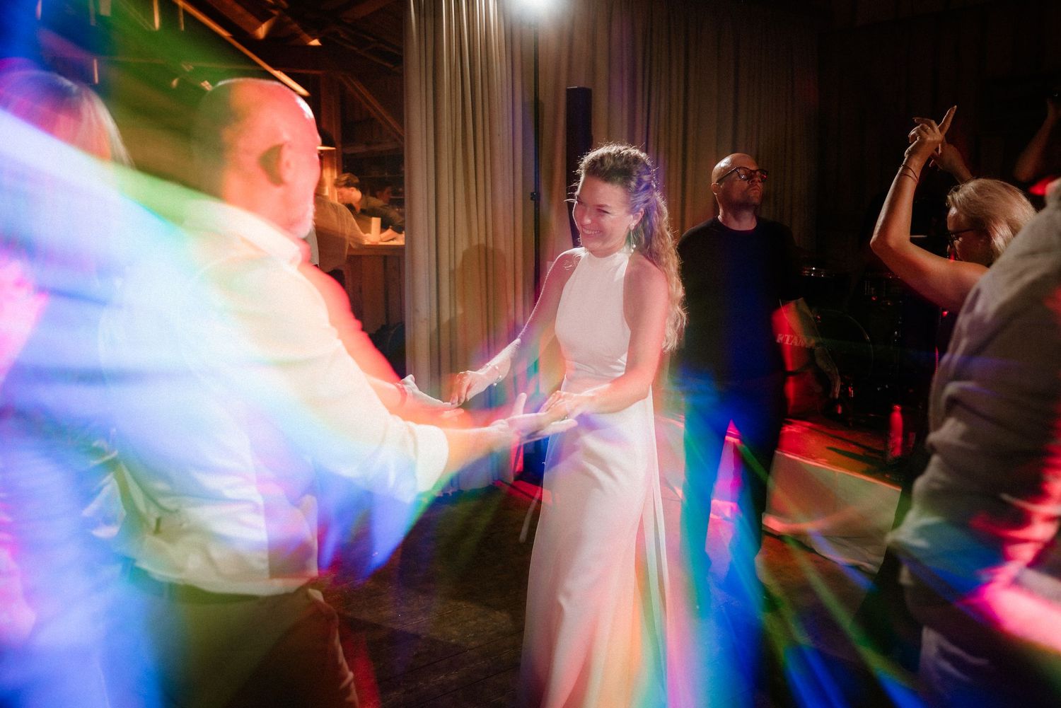 Dance party with colorful blue and pink lighting effects creating motion blur on the dance floor.
