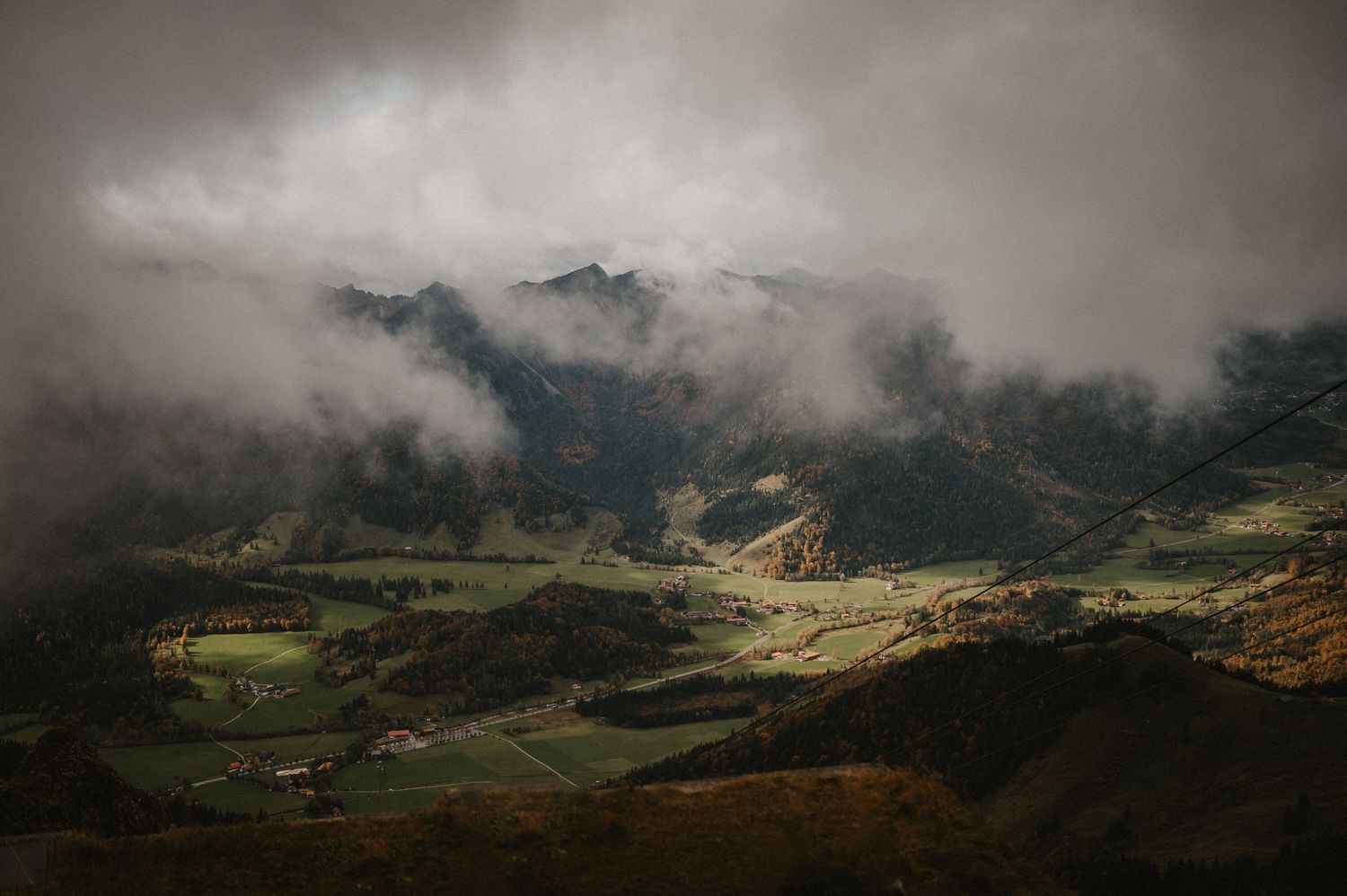 Panoramic view of misty mountains and valleys under dramatic cloudy skies.