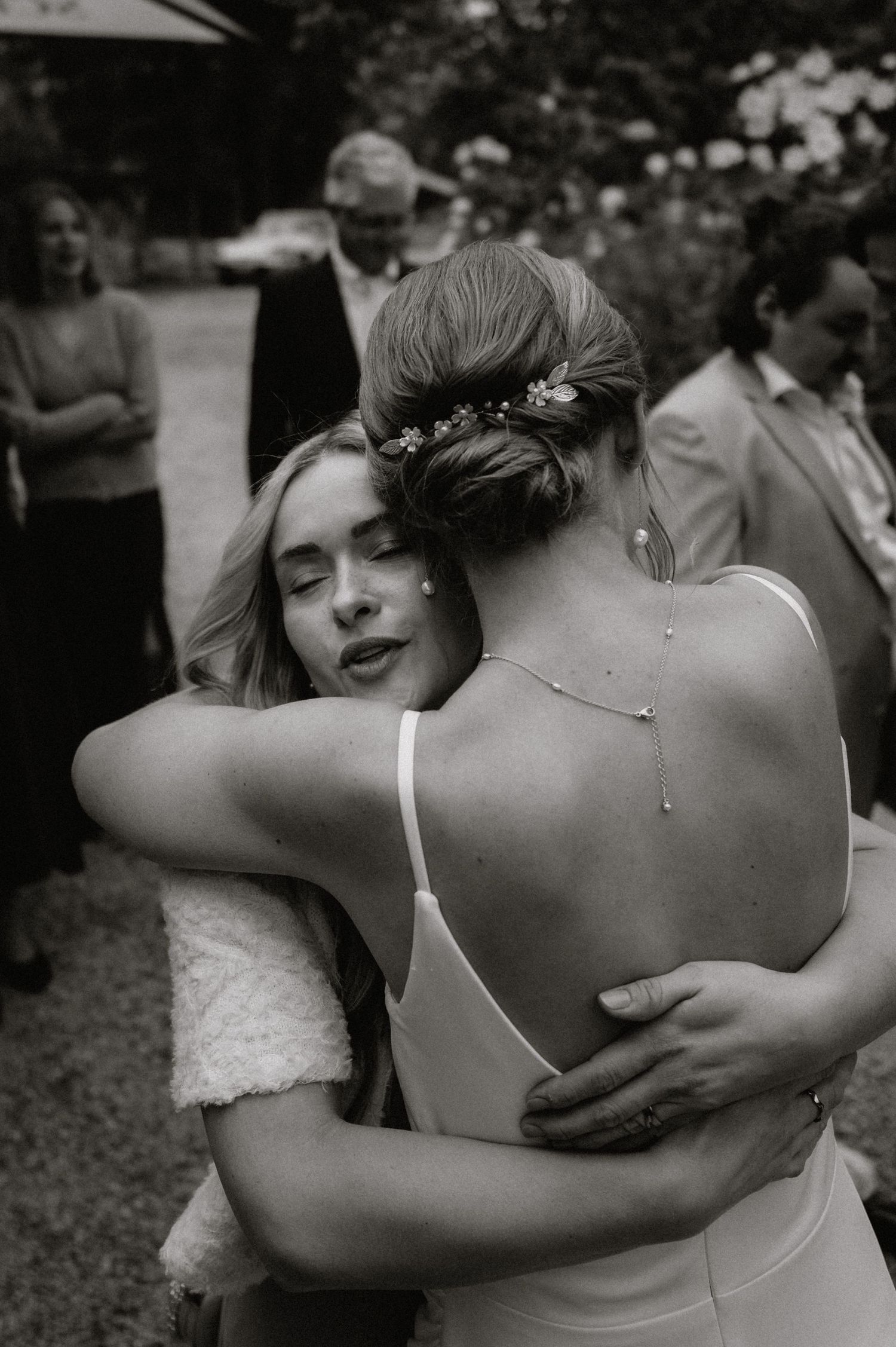 Two people share an intimate embrace at an outdoor wedding, showing emotion and connection.