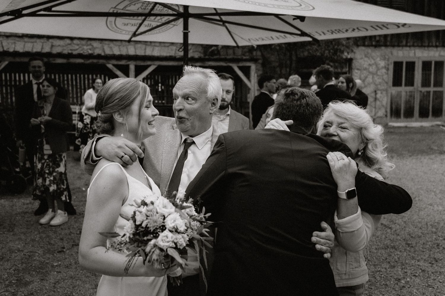 Guests gather to celebrate with the bride at an outdoor wedding reception.