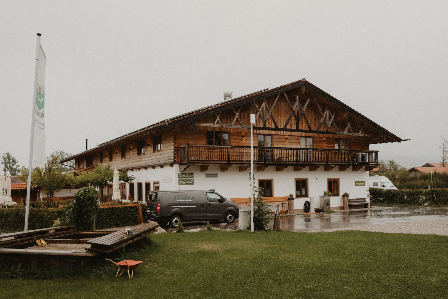 A panoramic view of traditional Bavarian farmhouses with rustic wooden architecture set against a rural landscape.