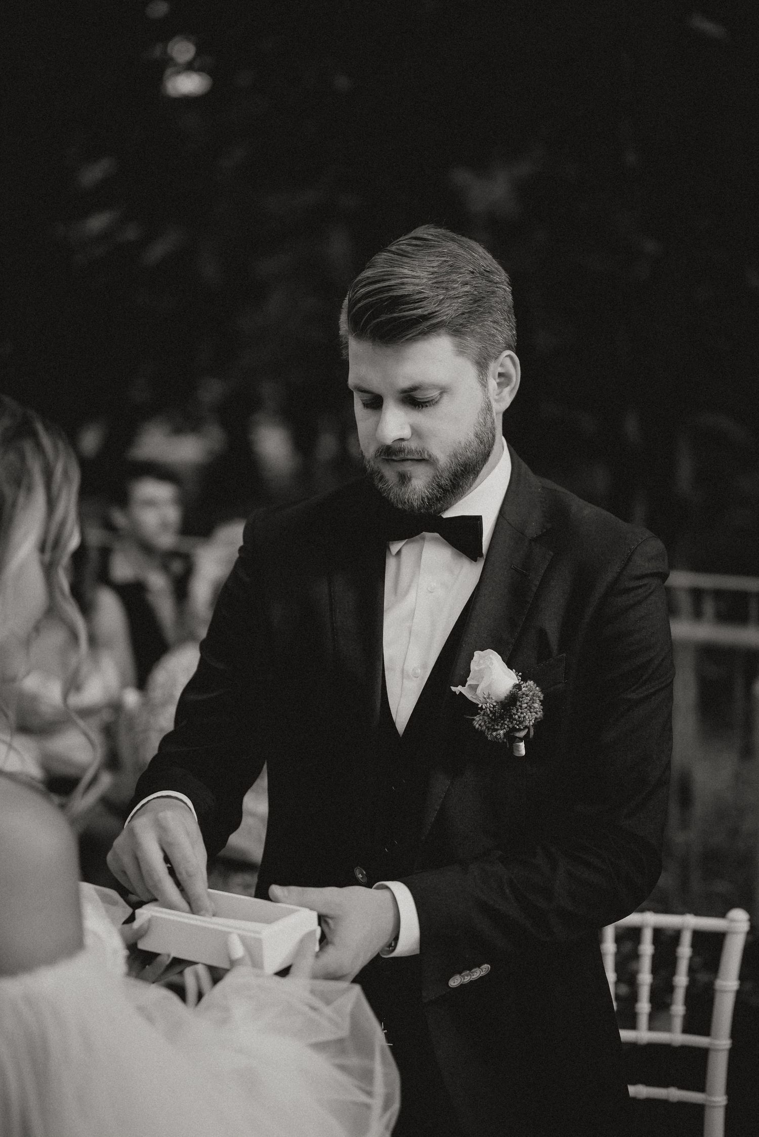 Black and white wedding photo showing intimate interaction during the ceremony.