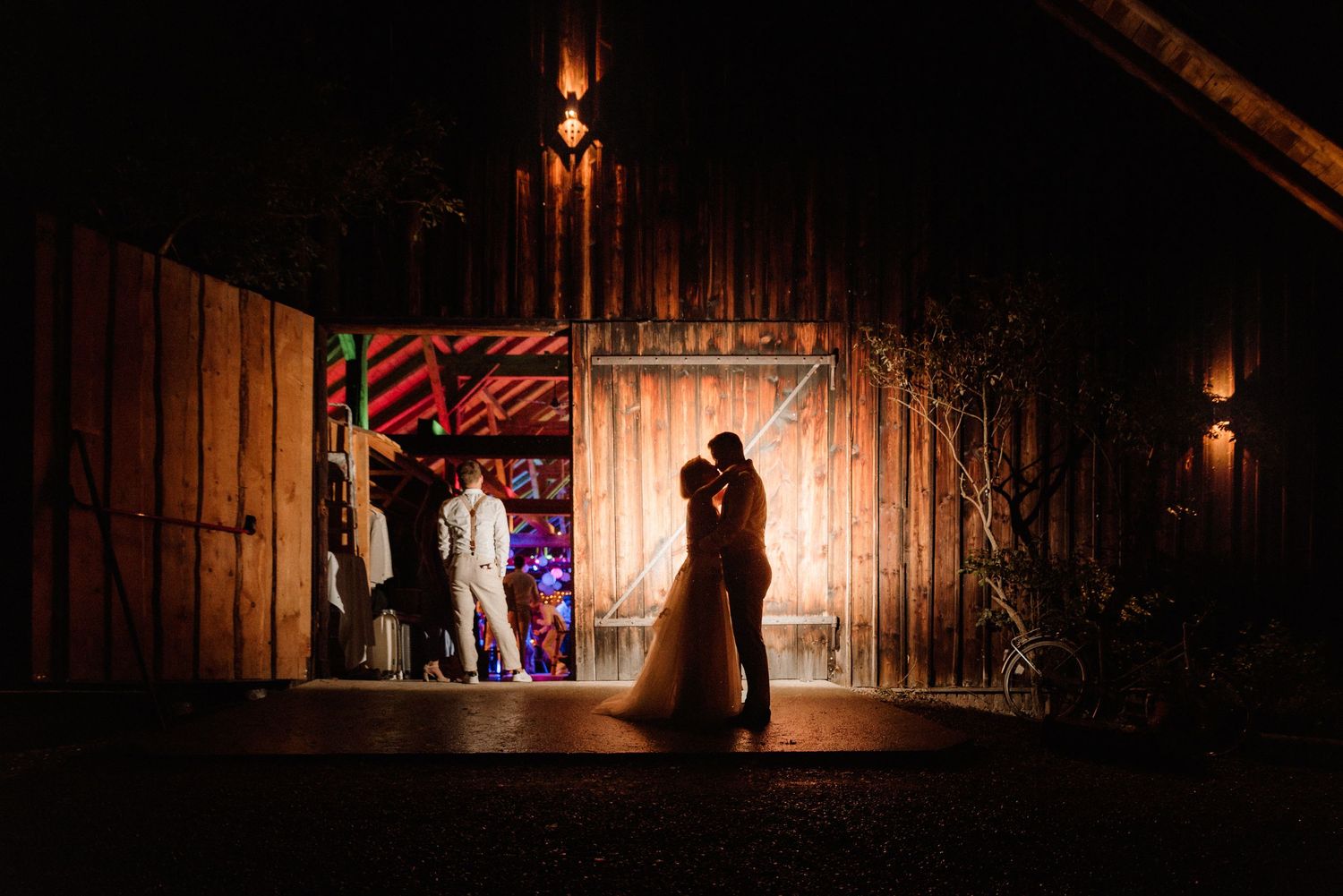 Rustic wooden barn interior lit by warm candlelight creating romantic ambiance.