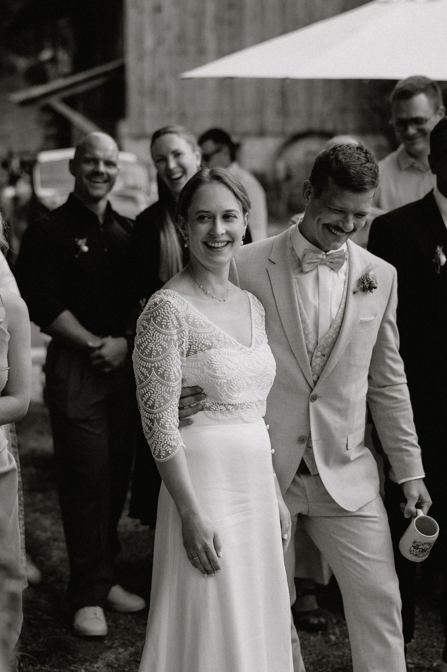 Wedding couple in elegant white attire share a moment during their celebration.
