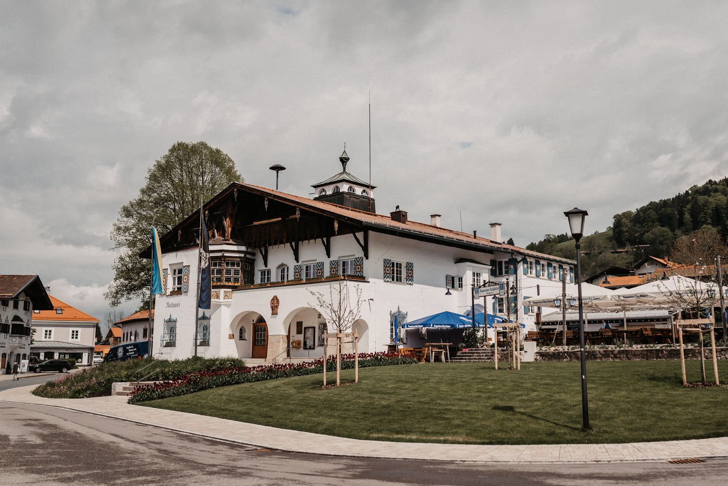 A traditional Bavarian-style building with white walls and blue trim stands on a corner in a quaint German village.