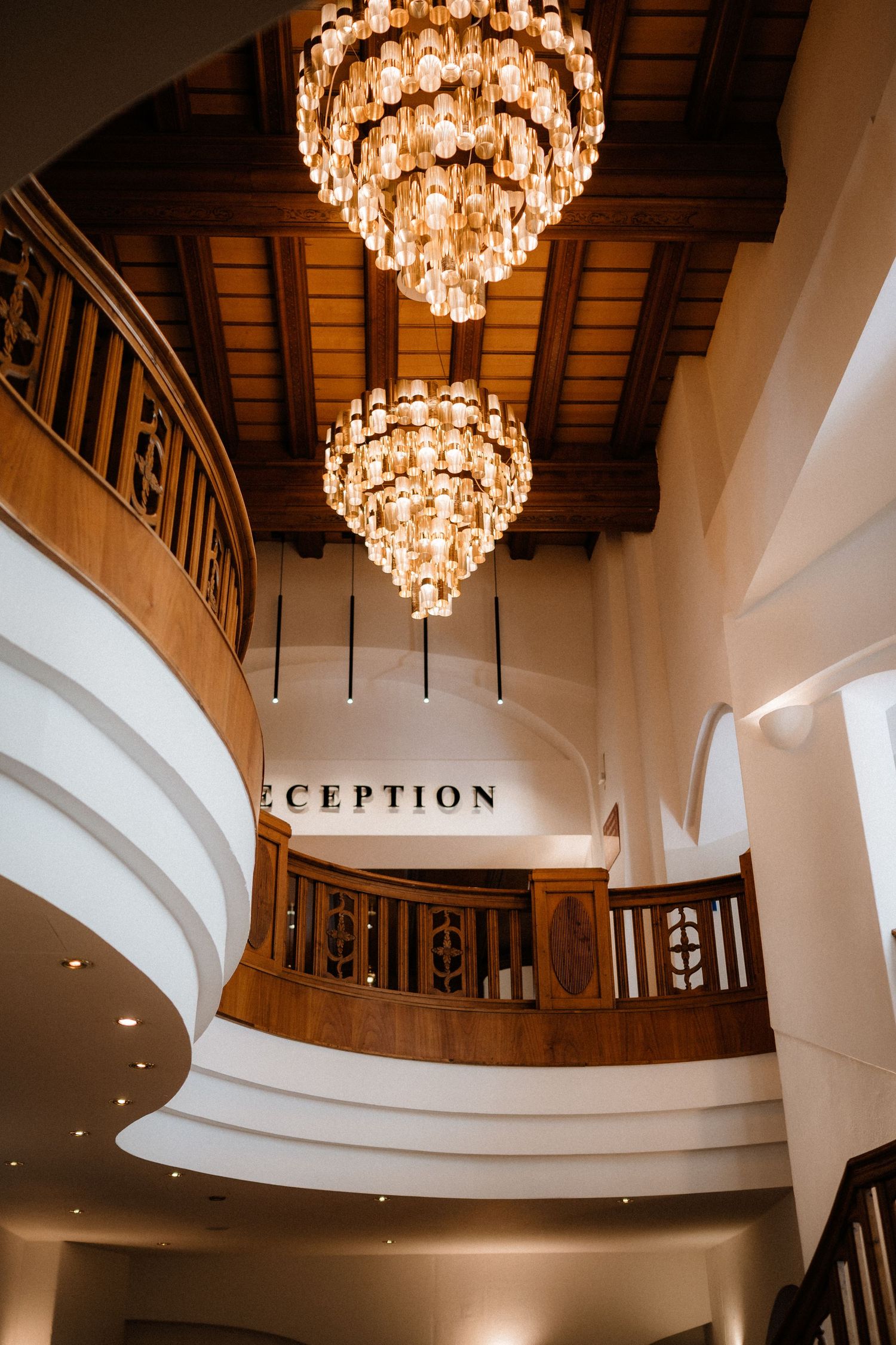 Grand reception hall with crystal chandeliers and wooden beam ceiling details.