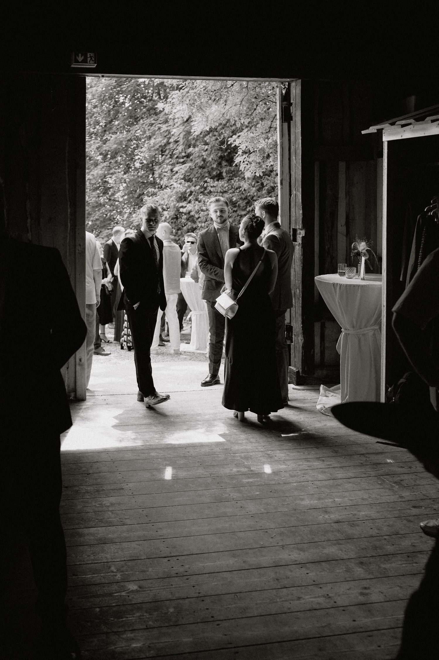 Black and white photos show guests mingling in a covered walkway at a formal event.