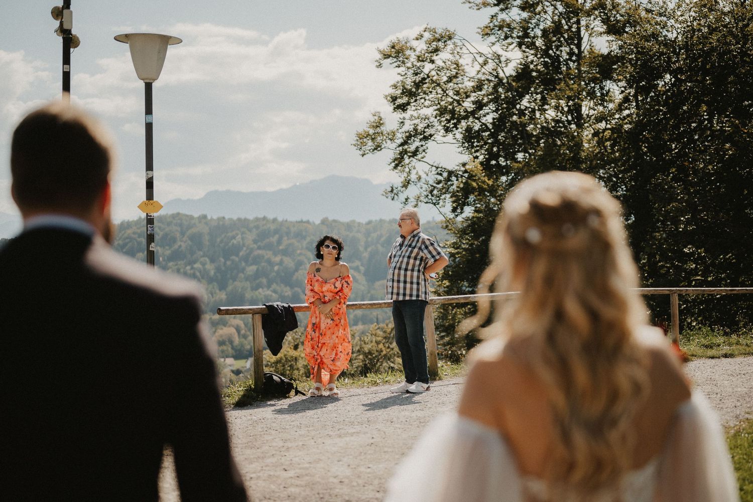A wedding ceremony scene with mountain views and guests in attendance.