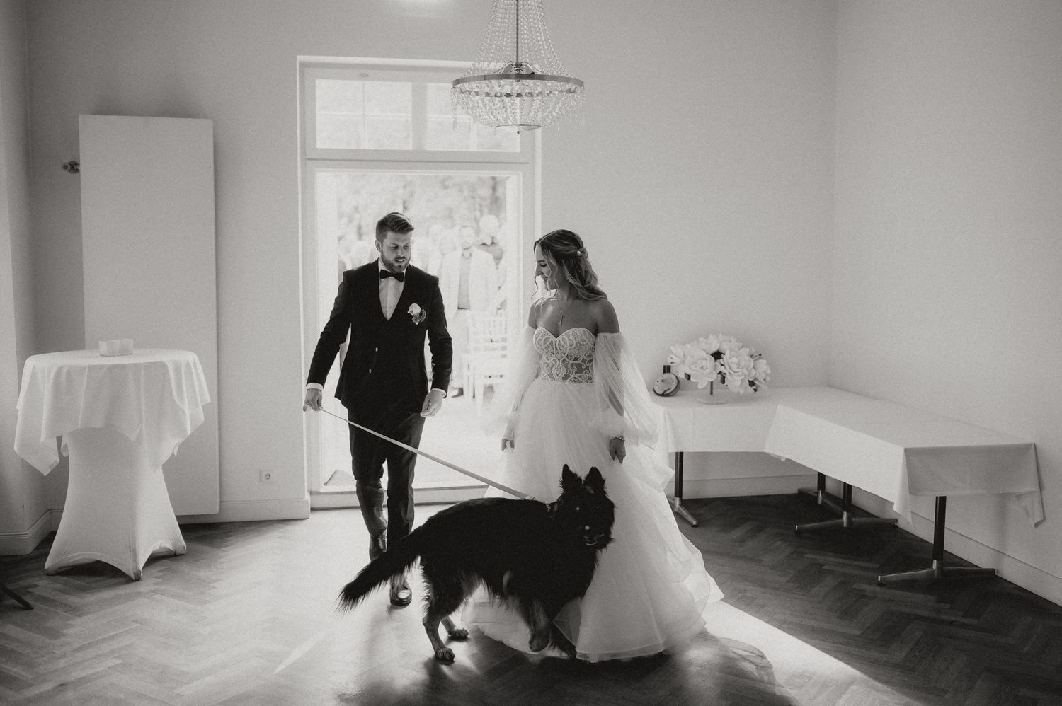 Black and white wedding photo sequence showing couple walking through a bright hallway.