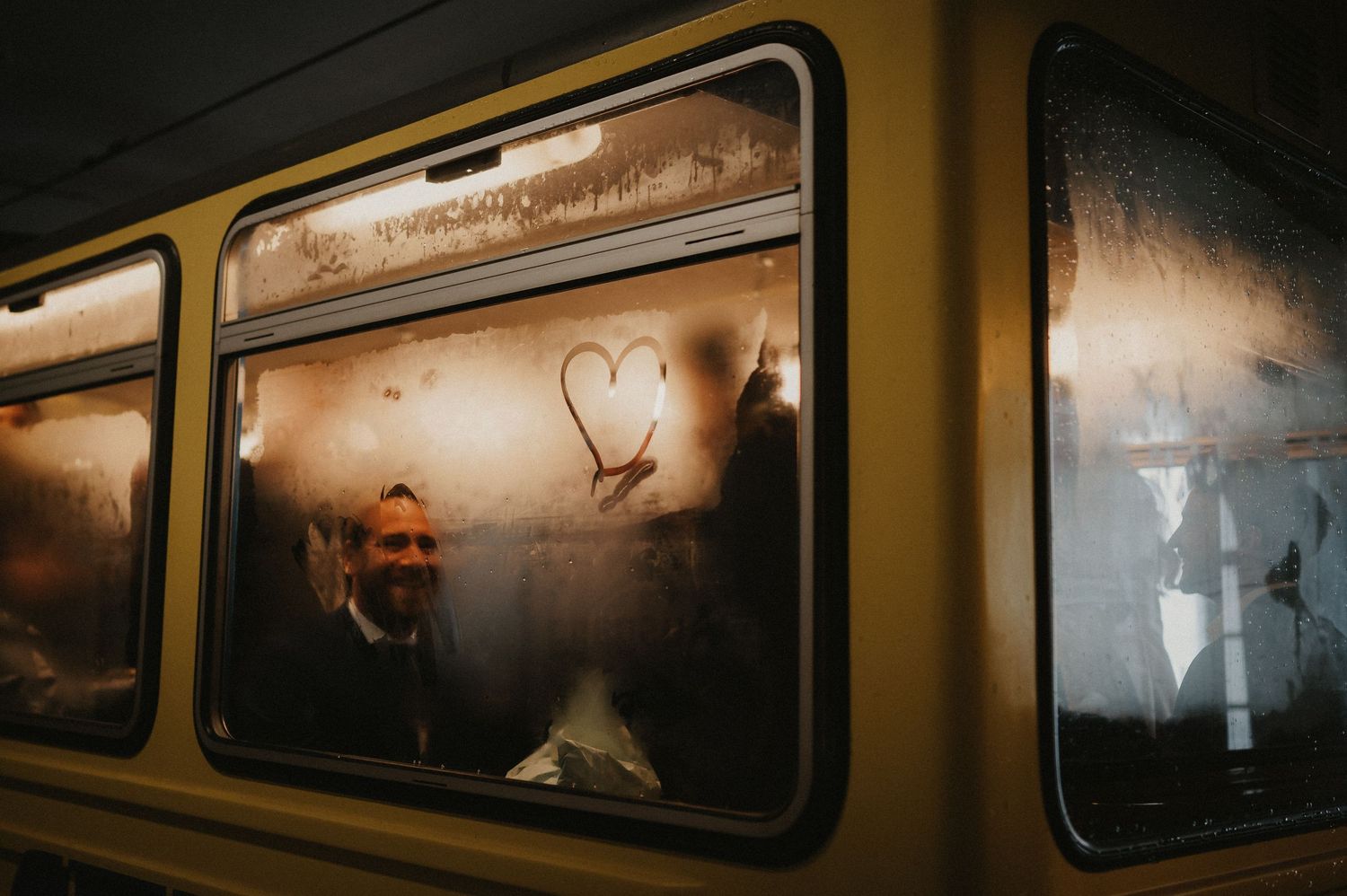 Dramatic silhouette of a subway train car window with moody lighting and shadows.