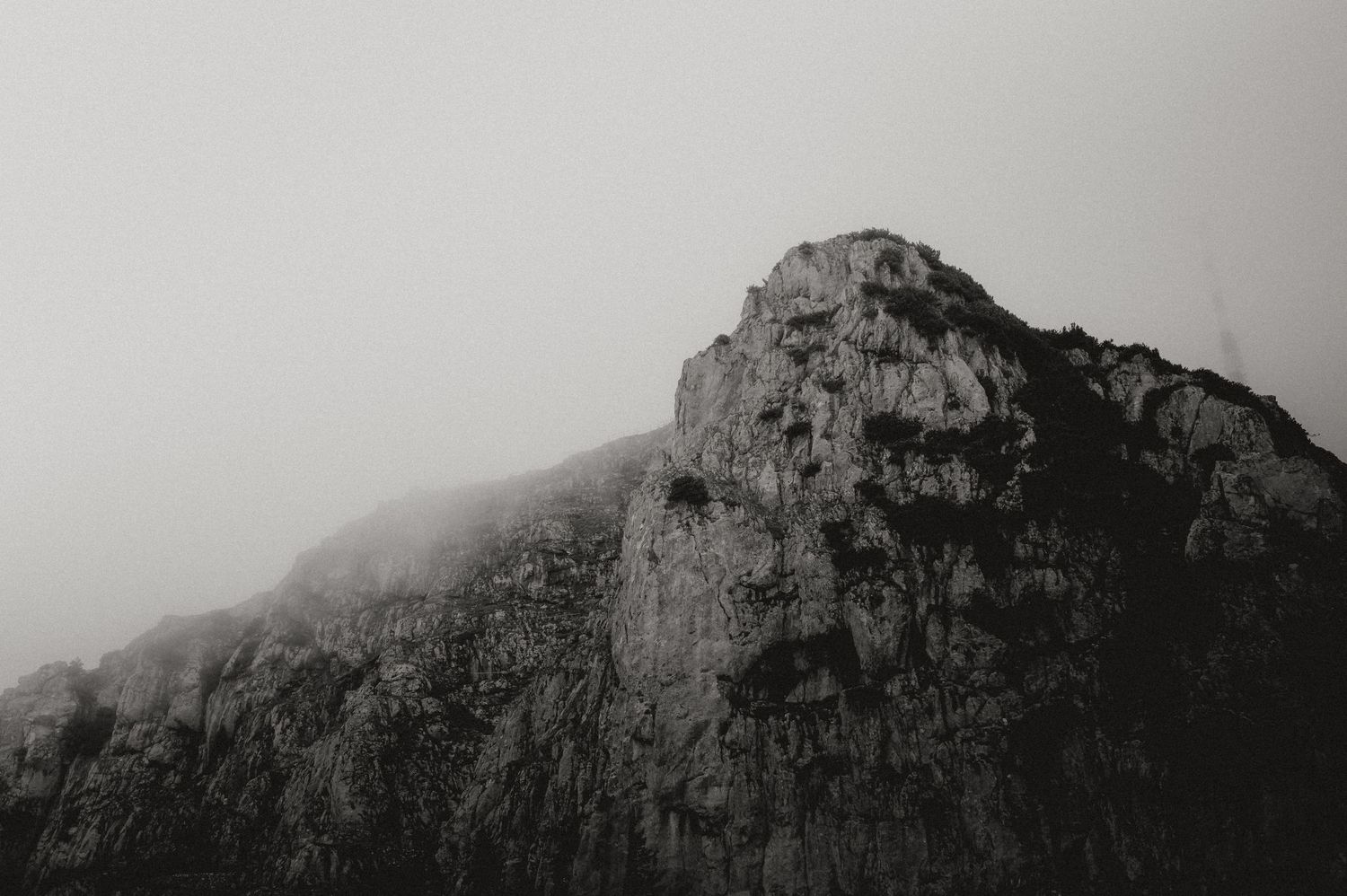 Dramatic mountain landscape with misty peaks in black and white.
