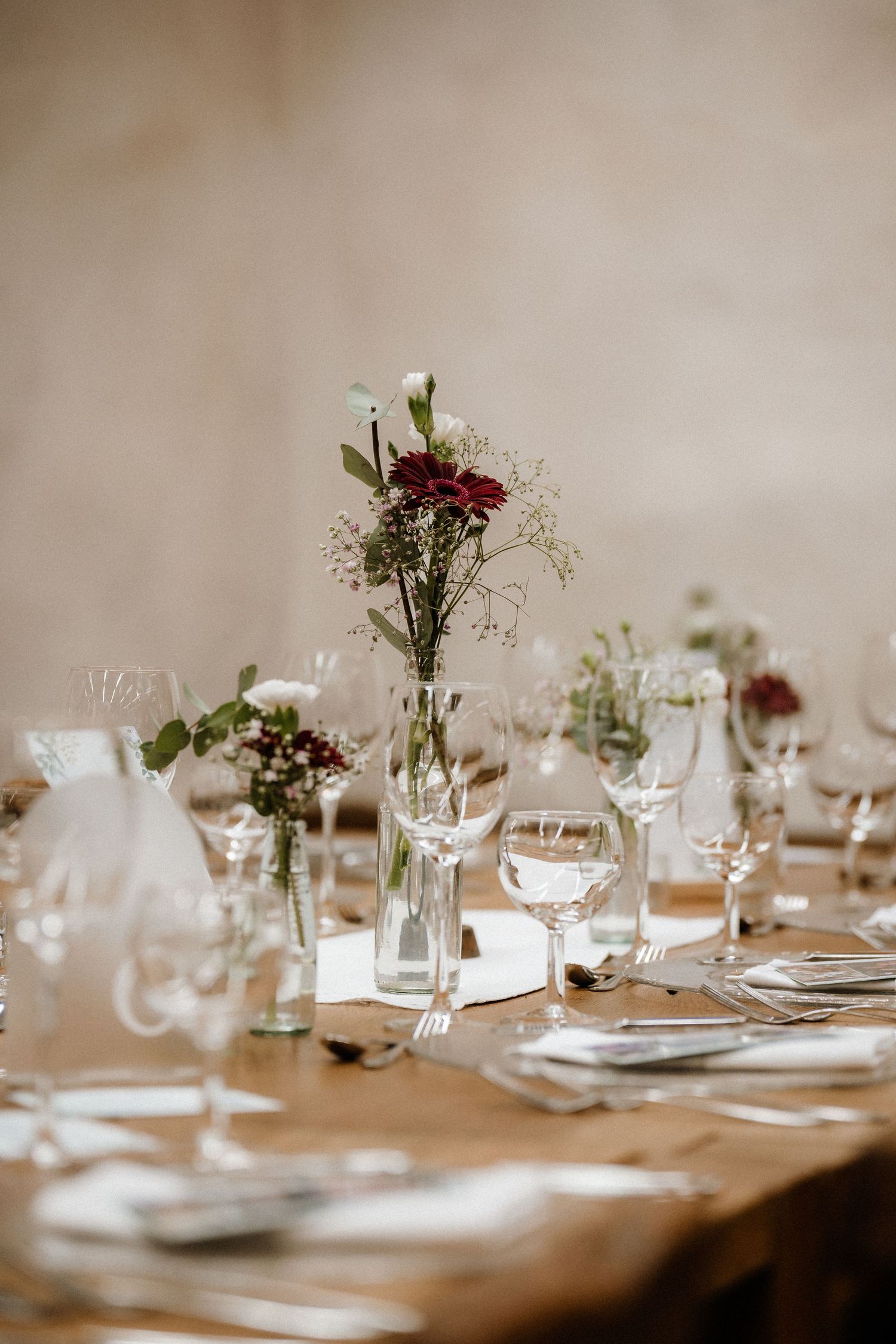 Elegant table settings with delicate floral centerpieces at wedding reception.