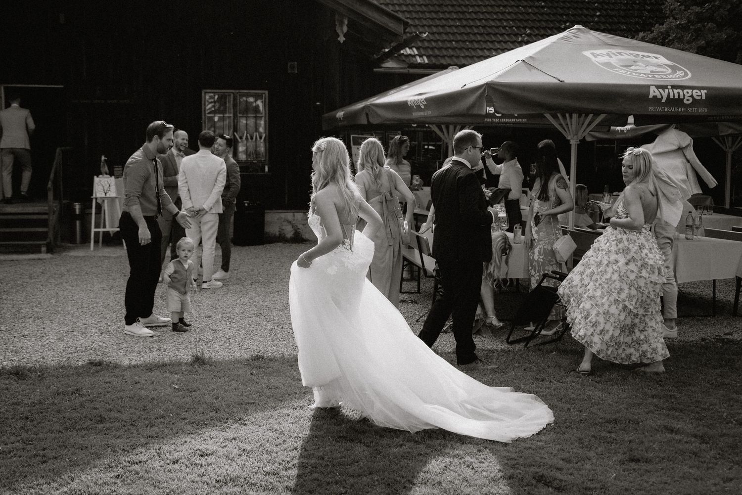 Wedding guests dance and celebrate on outdoor patio during reception.