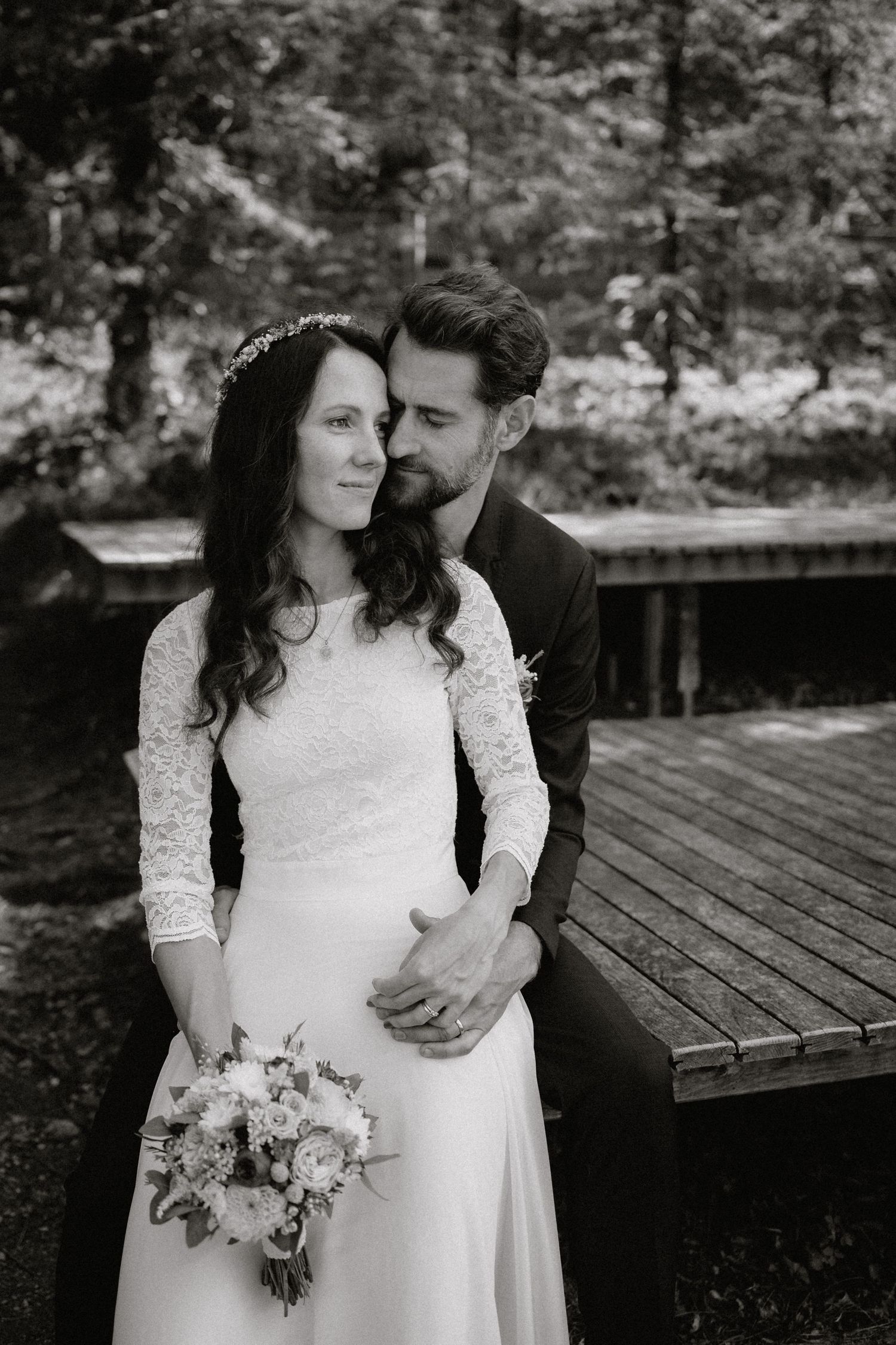 Intime schwarz-weiße Hochzeitsporträts, die auf einer rustikalen Holzbank aufgenommen wurden. Von Dama Fotografie Bad Tölz