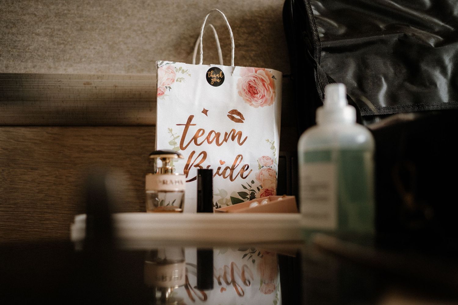 Wedding day details including cards and beauty products arranged on wooden surface.