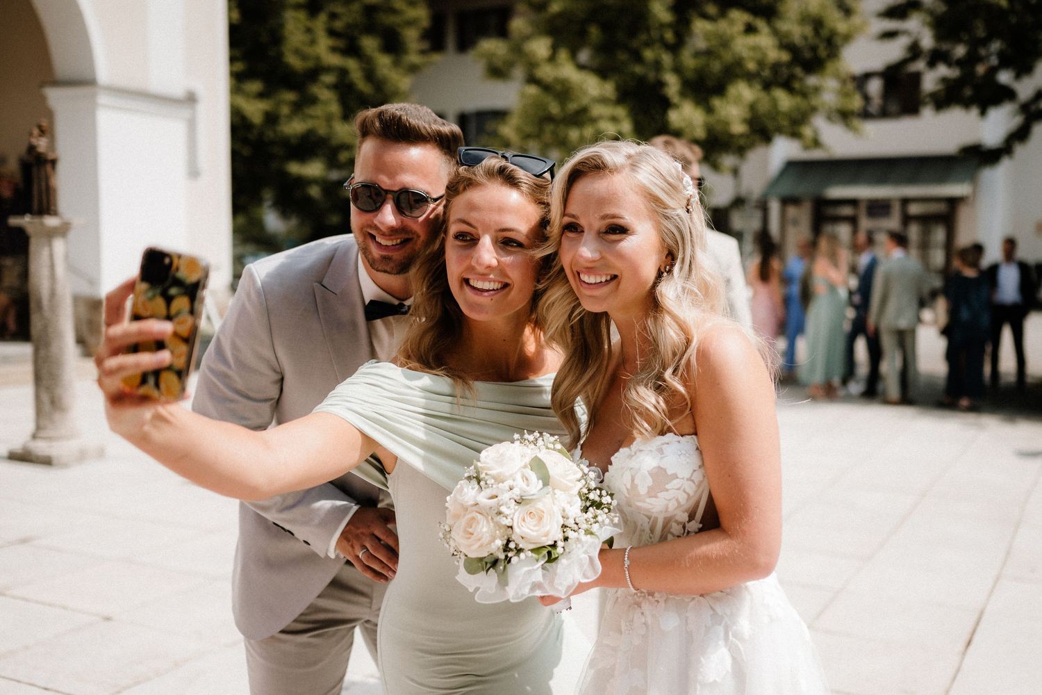 Wedding party posing together outside on a bright summer day.