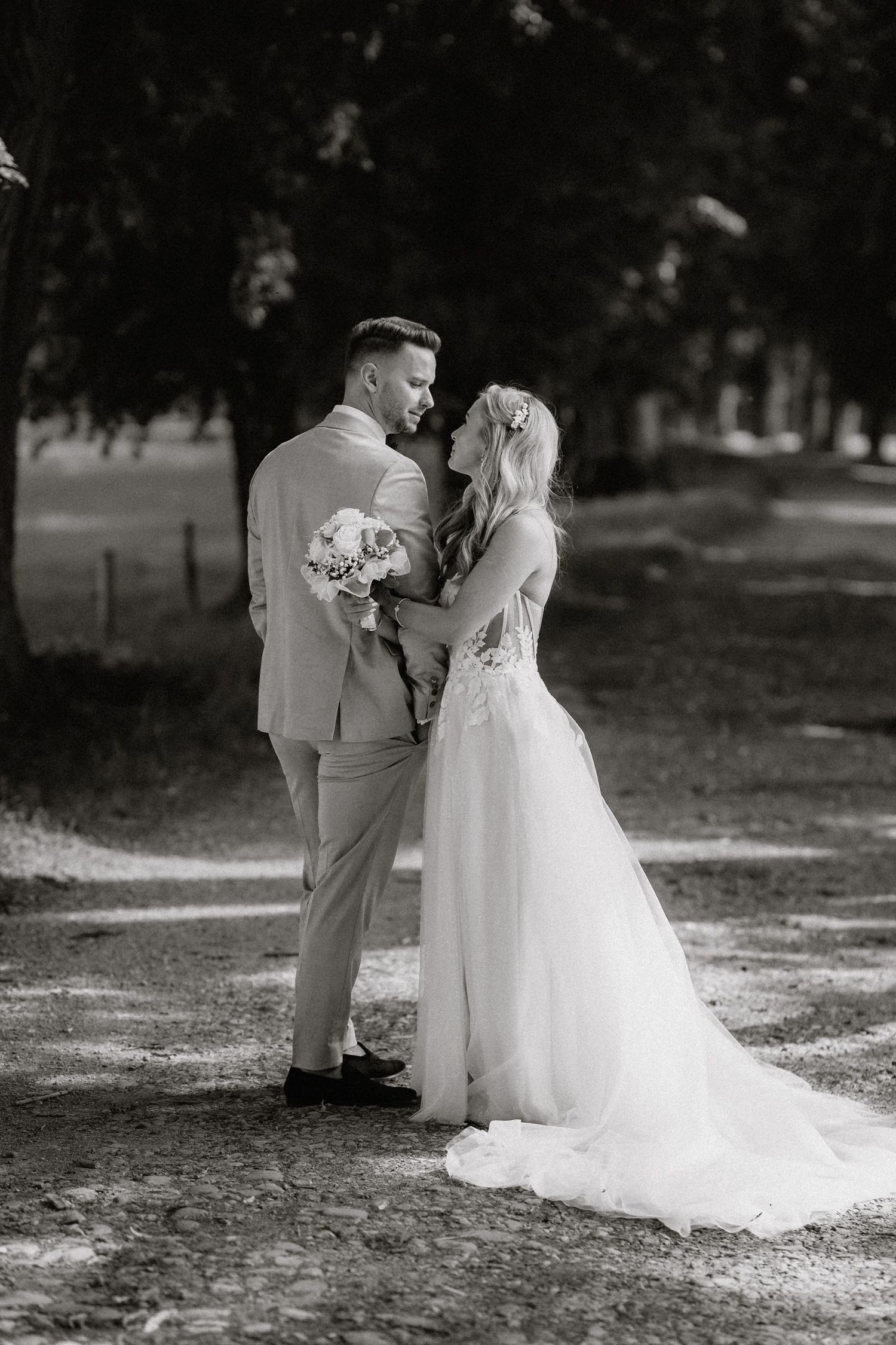 Black and white wedding portraits showing tender moments between newlyweds on a garden path.