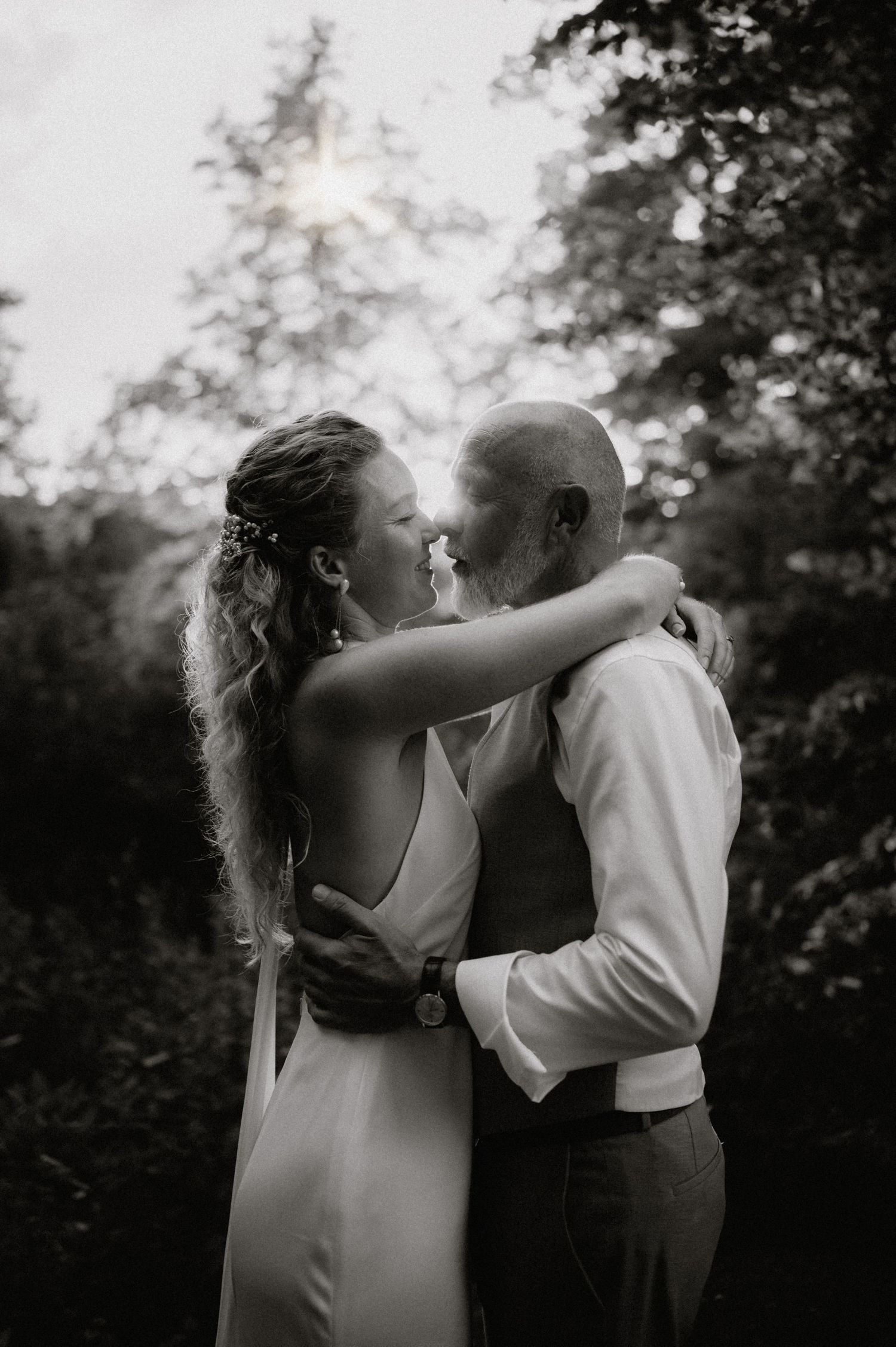 A black and white photo captures an intimate dance between a couple in wedding attire.