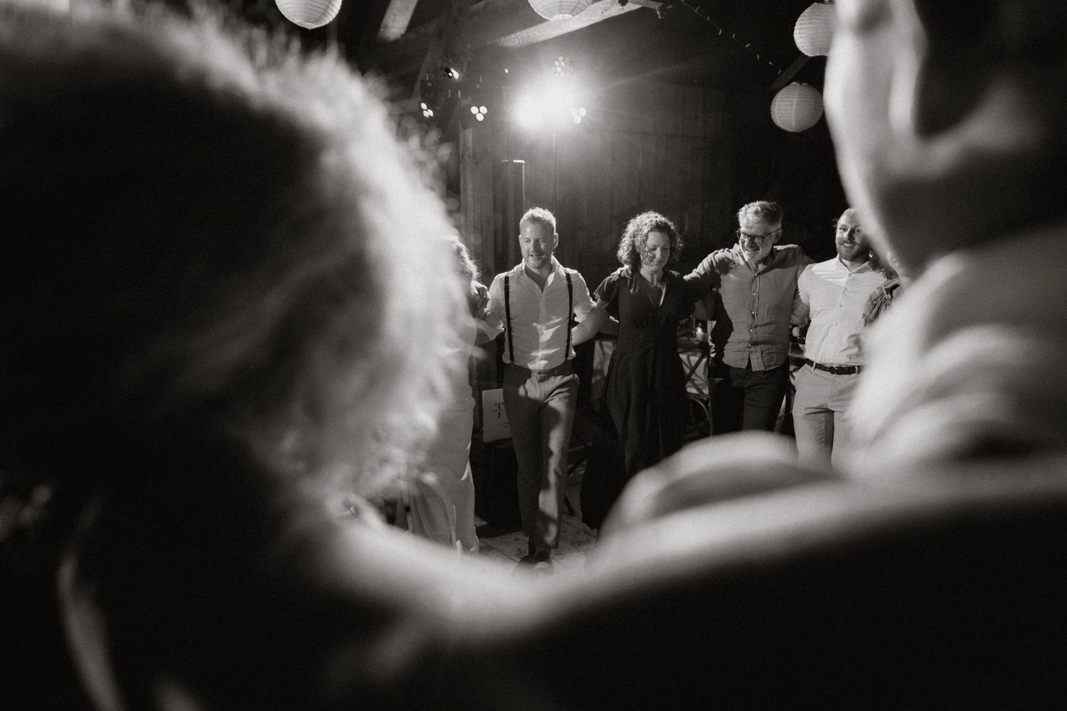 Black and white shot of a dimly lit dance floor with bokeh lights creating a dreamy atmosphere.