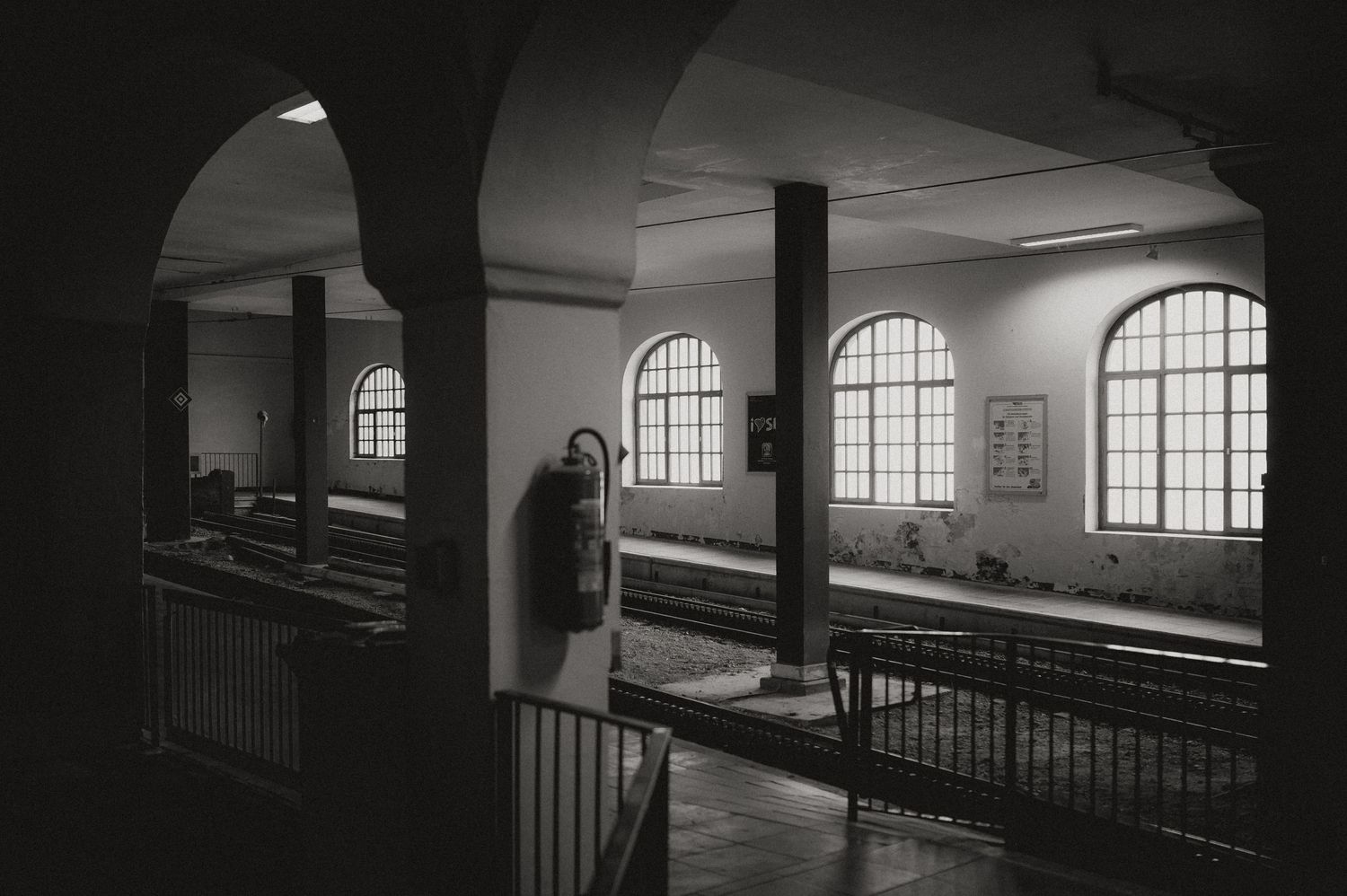 Interior of a historic building with arched windows and dramatic lighting.