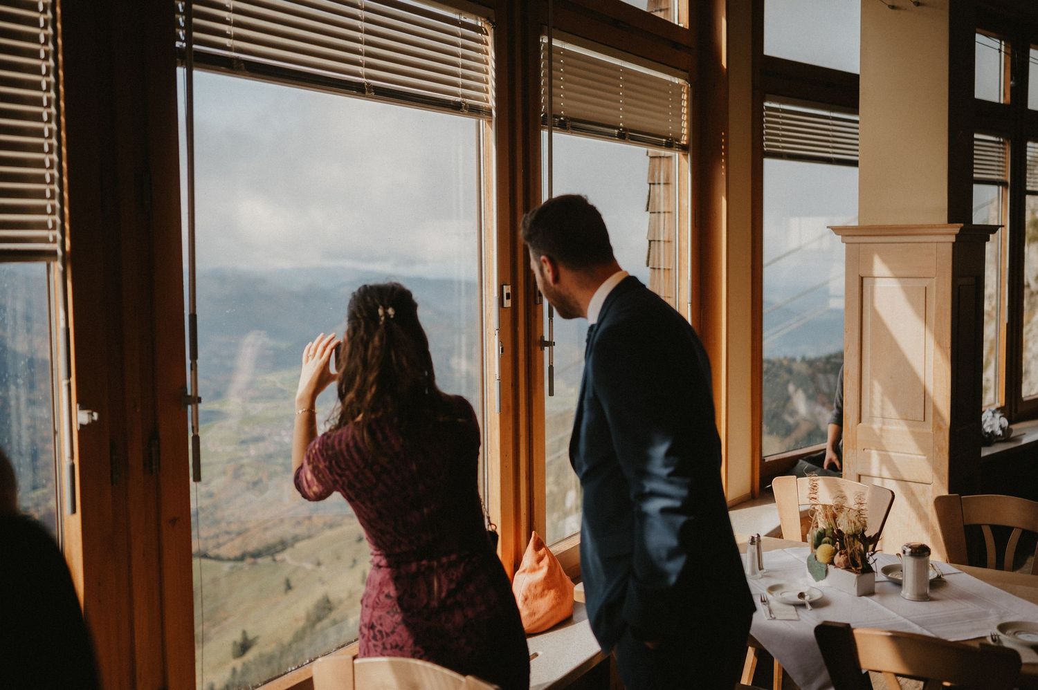 Interior of mountain lodge with large windows offering scenic valley views.