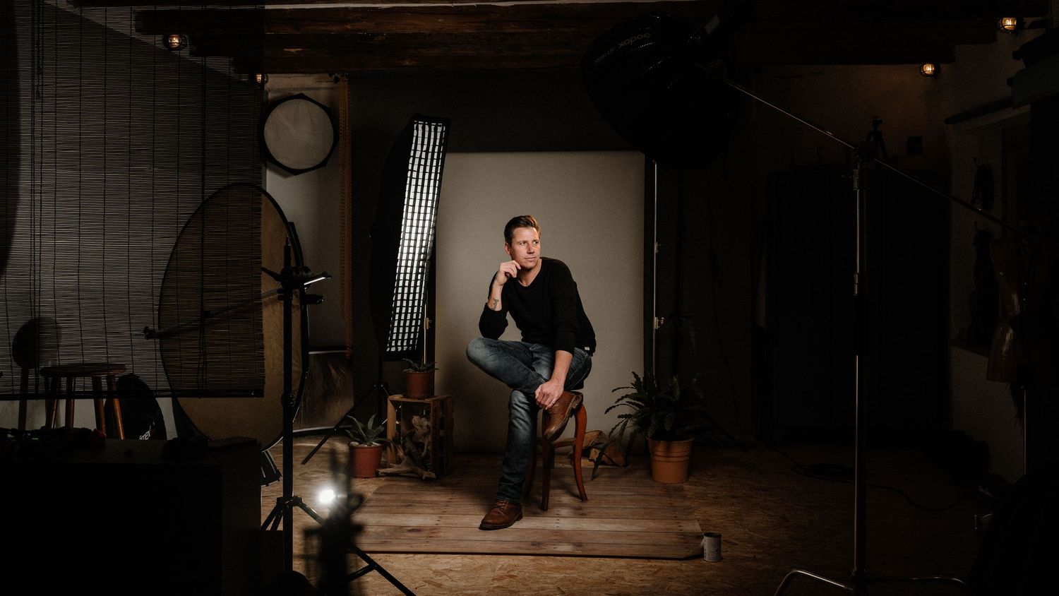 Blick hinter die Kulissen eines Fotostudios mit Beleuchtungsausrüstung und Hintergrund. Von Dama Fotografie Bad Tölz