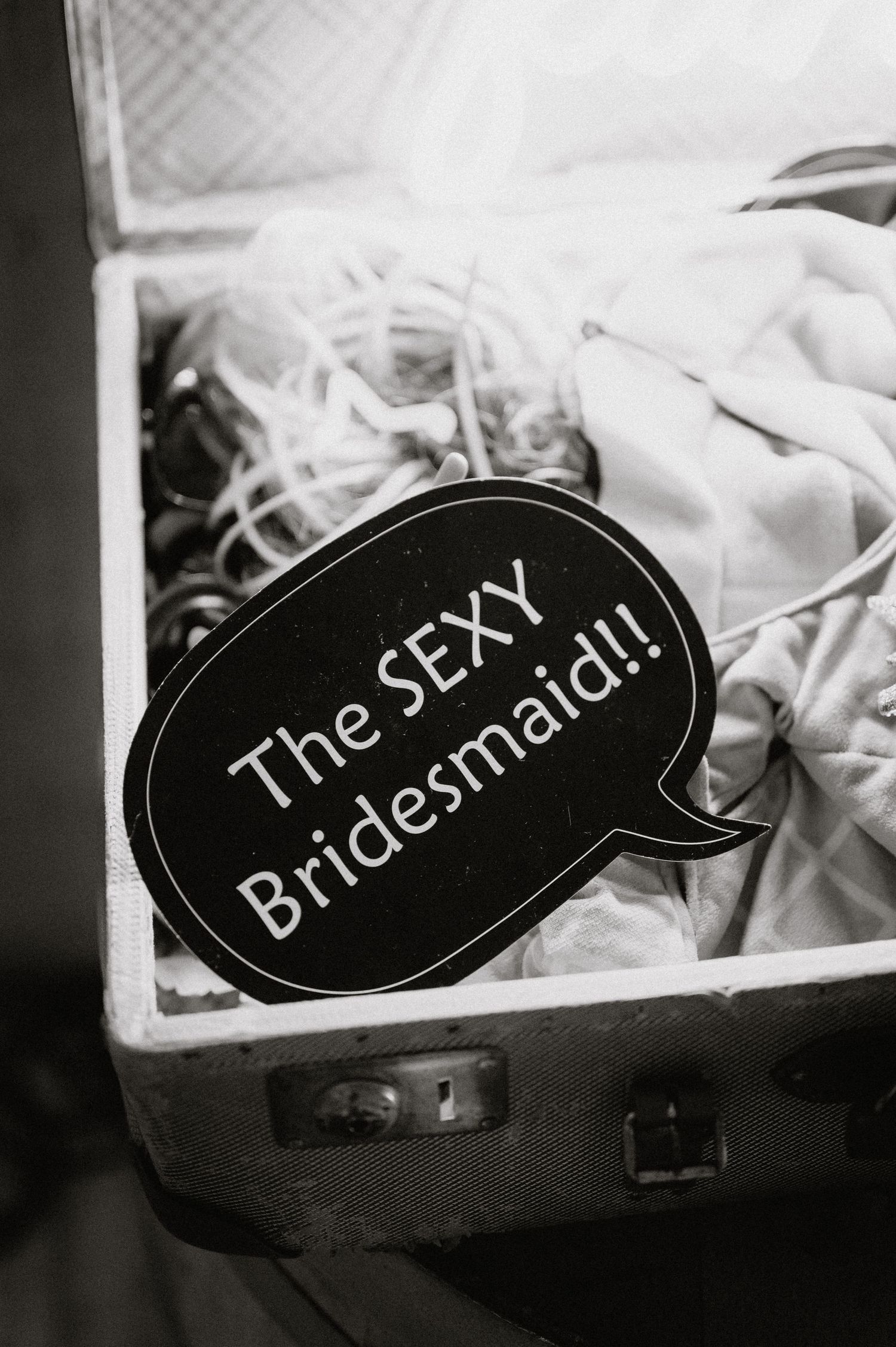 Black and white decorative signs with text displayed against white fabric.