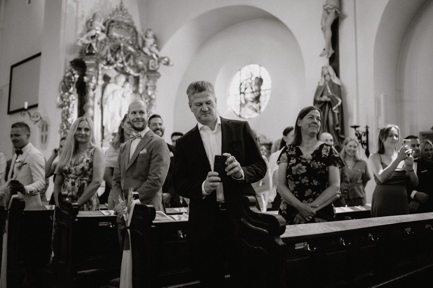 Wedding guests seated in church pews during a ceremony.
