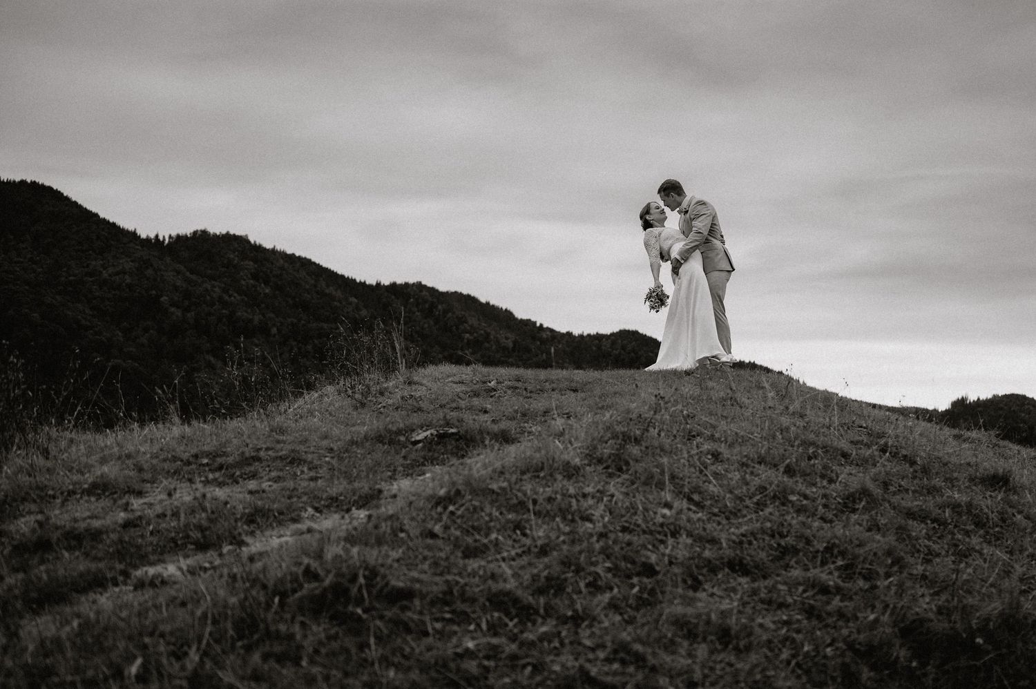A couple walks along a scenic mountain ridge during a moody overcast day.