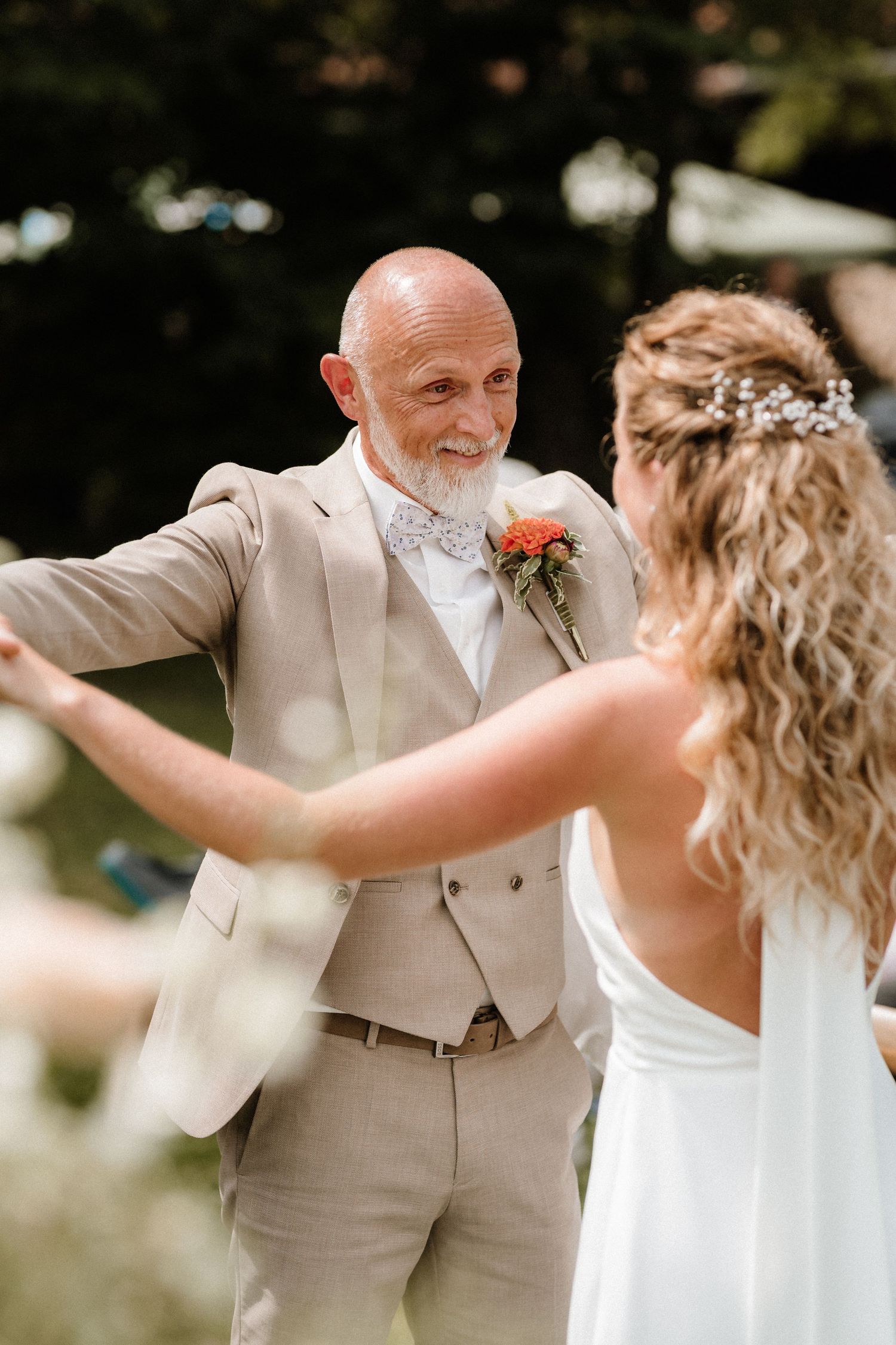 A couple performs a lively dance together at their outdoor wedding celebration.