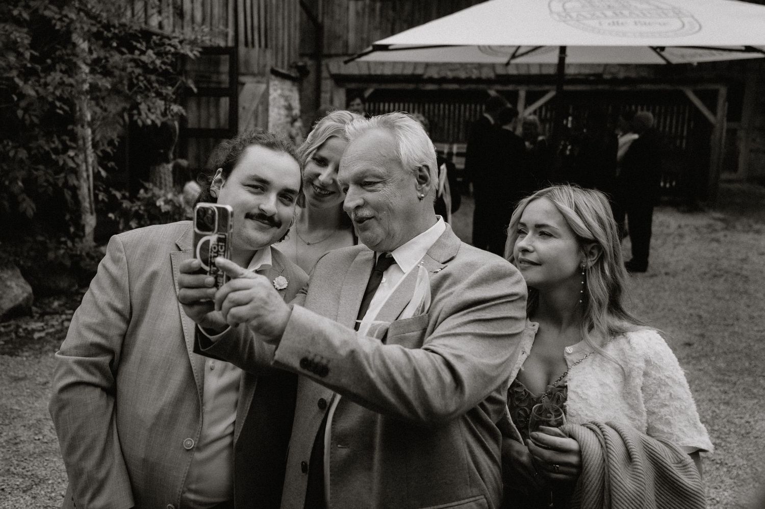 Guests share drinks and laughter during outdoor wedding reception.
