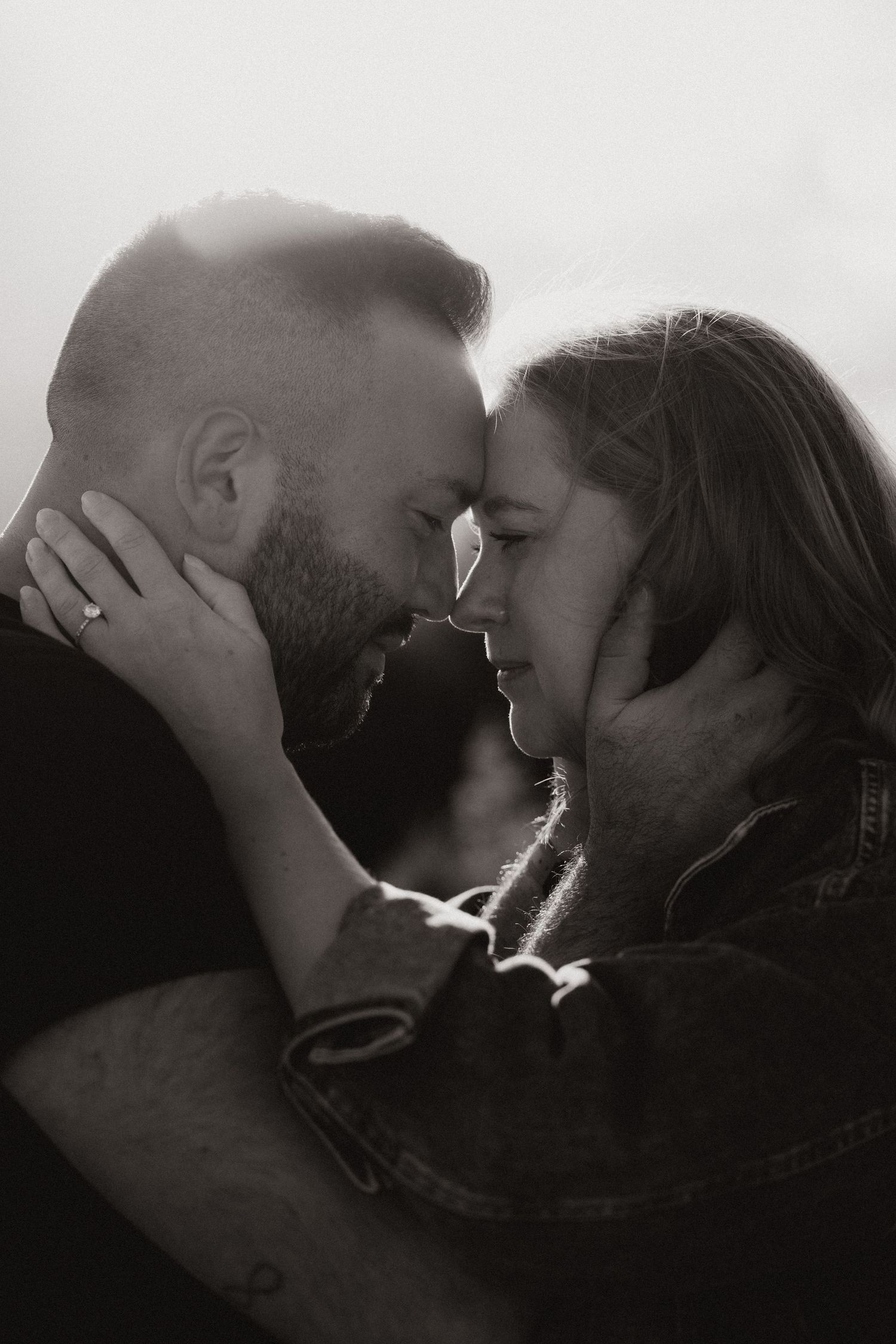 Couple touching foreheads in an intimate black-and-white moment during a documentary family session.