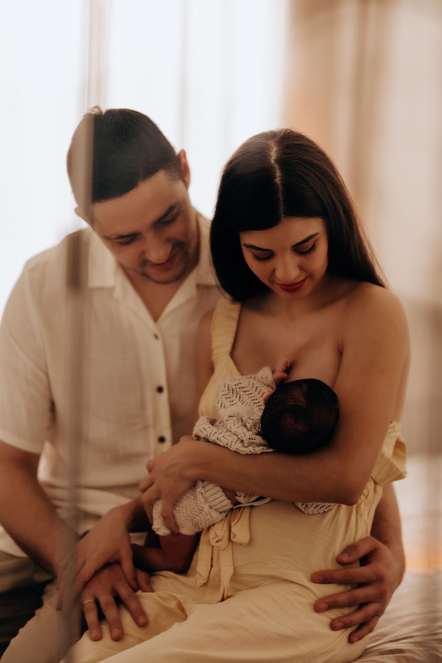 Parents holding their newborn during an in-home lifestyle newborn session with natural light, in Stoke on Trent