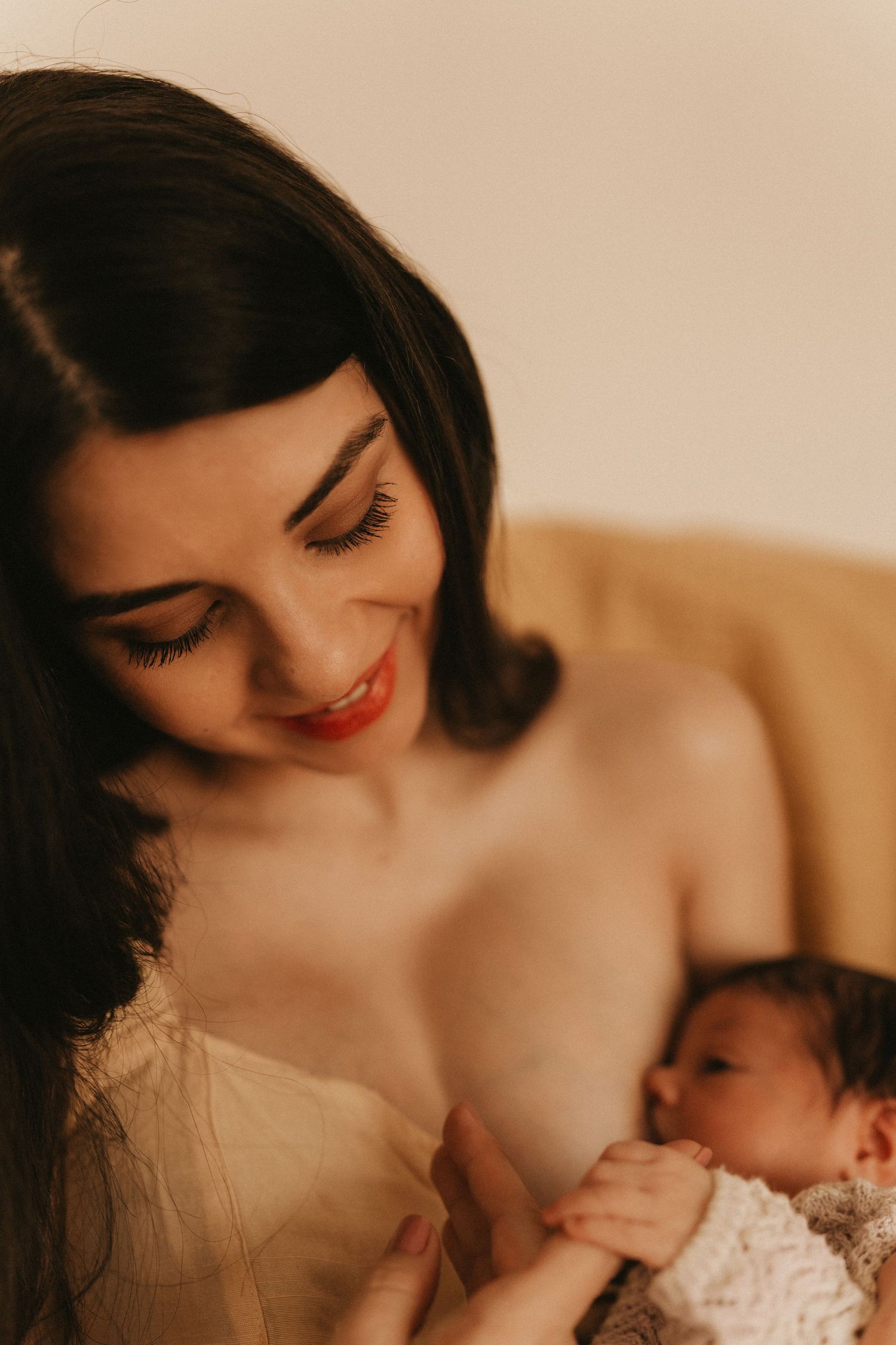 Mother breastfeeding her newborn during a soft storytelling newborn photoshoot at home in Stoke on Trent