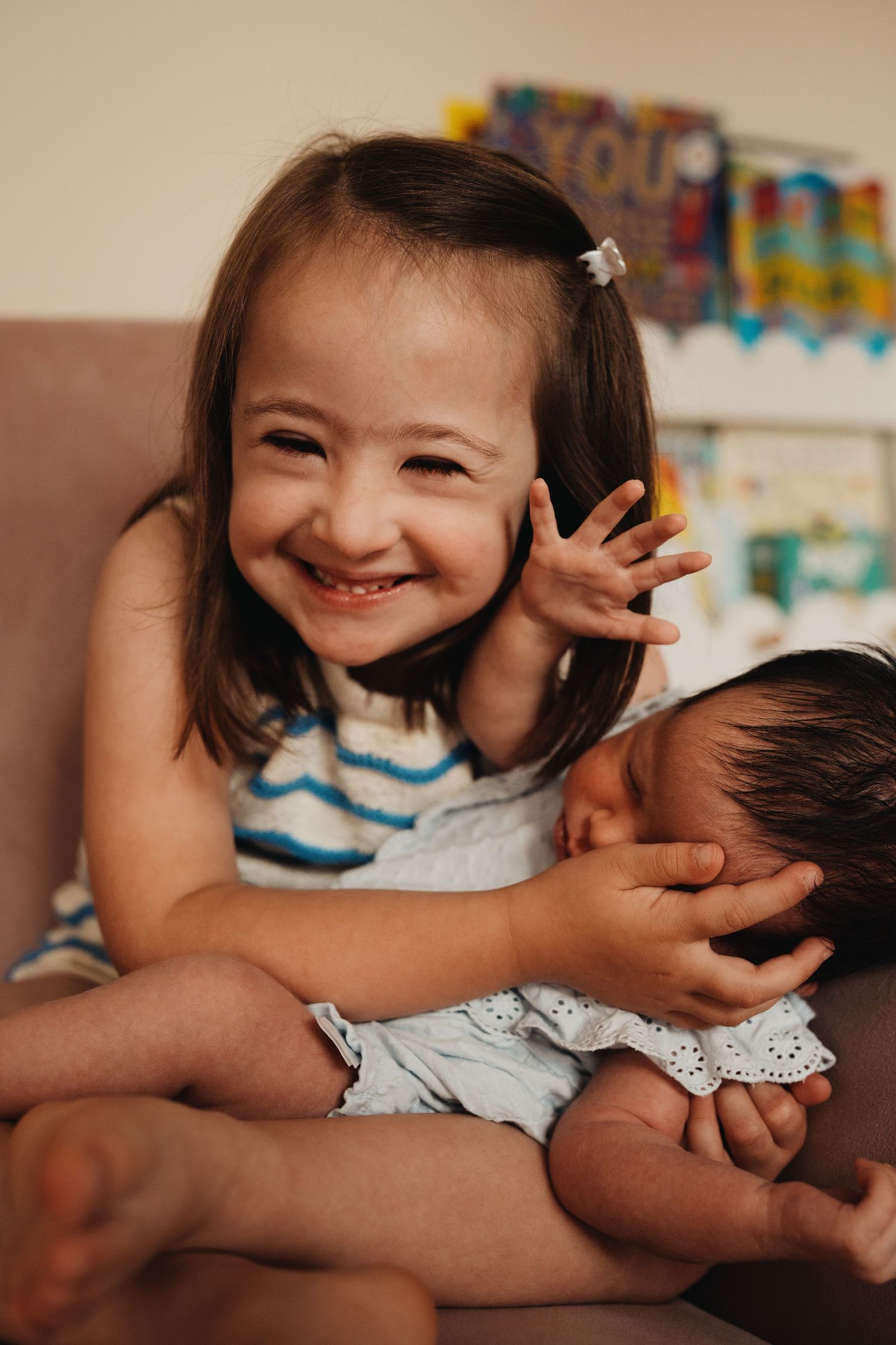Older sibling cuddling a newborn during an in-home lifestyle family and newborn photography session in Moira