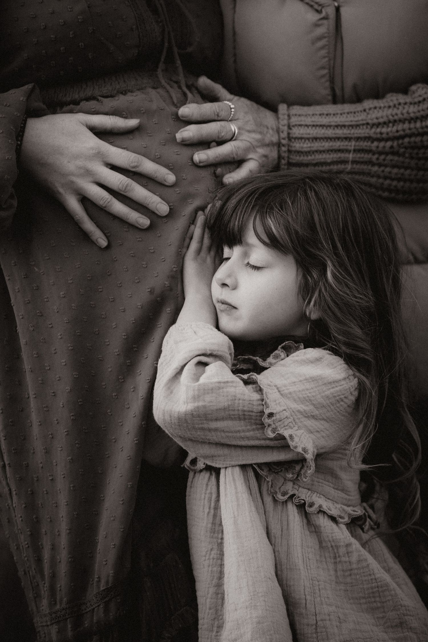 Child resting against a pregnant belly during an intimate outdoor documentary maternity session. generational photoshoot in Asby