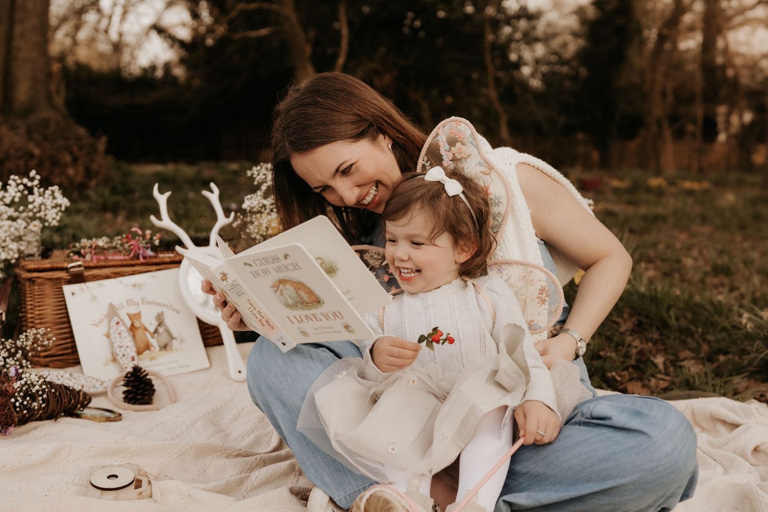 Mother and daughter read a book together on a picnic blanket during a storytelling family photoshoot in Tamworth