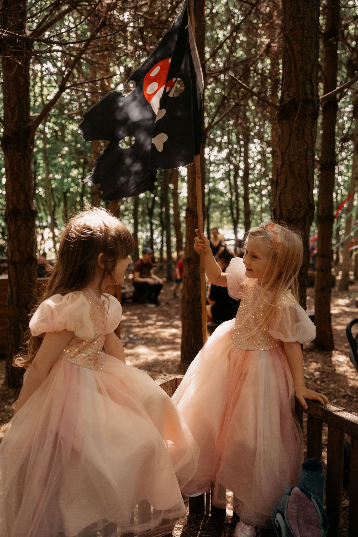 Two little girls in soft tulle dresses playing in woodland light – magical childhood photography in Tamworth.