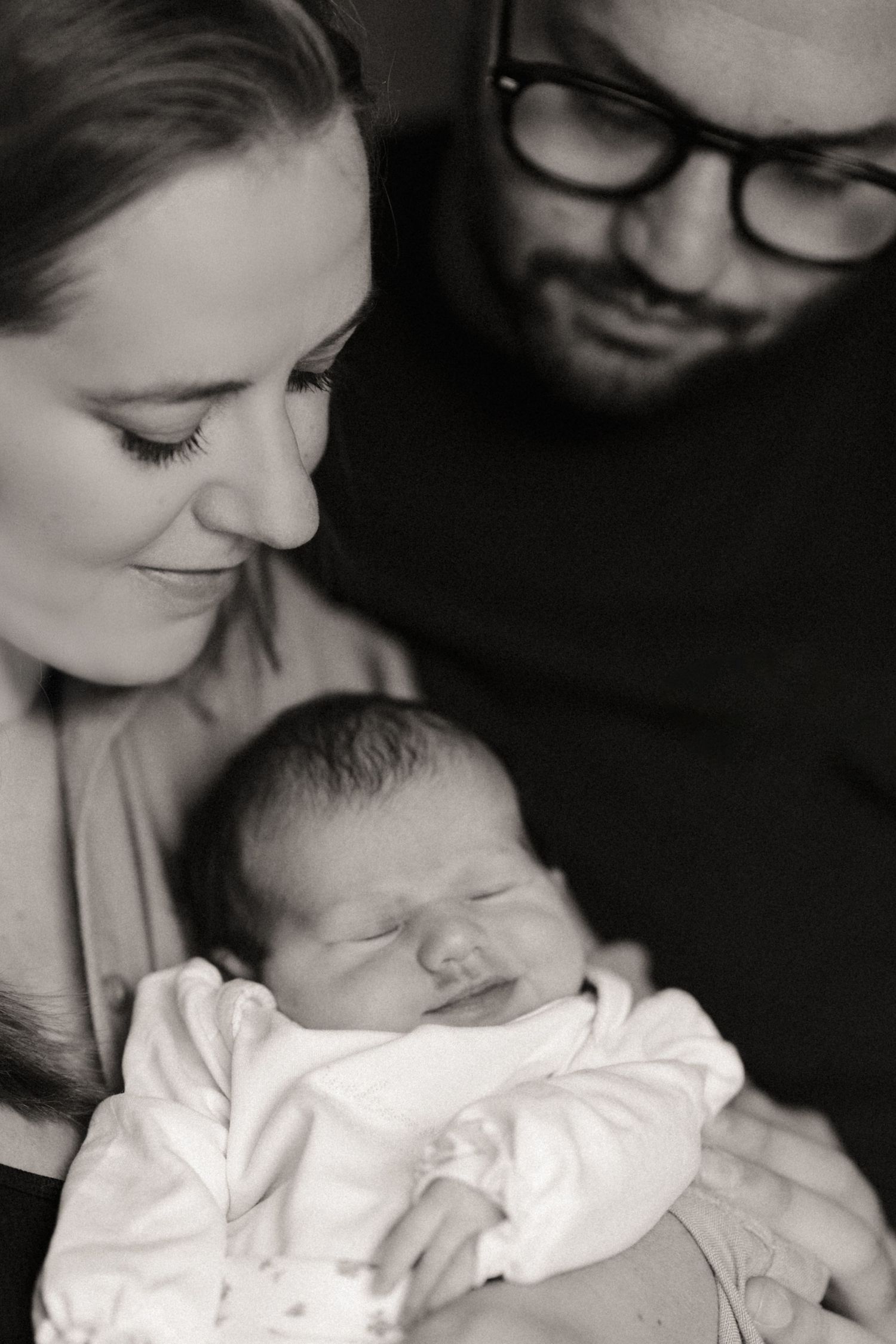 Parents admiring their sleeping baby during an intimate lifestyle newborn photoshoot at home in Tamworth