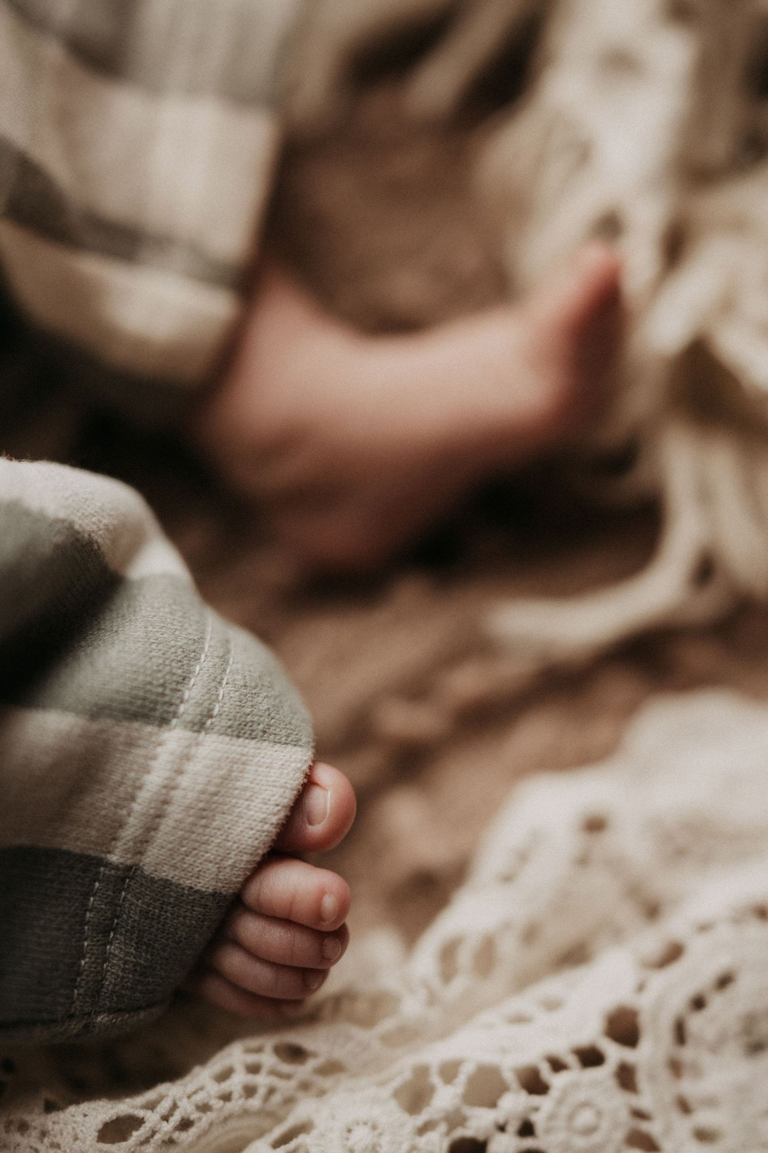 Newborn feet resting on a blanket during a soft natural light lifestyle newborn session in Ashby de la Zouch