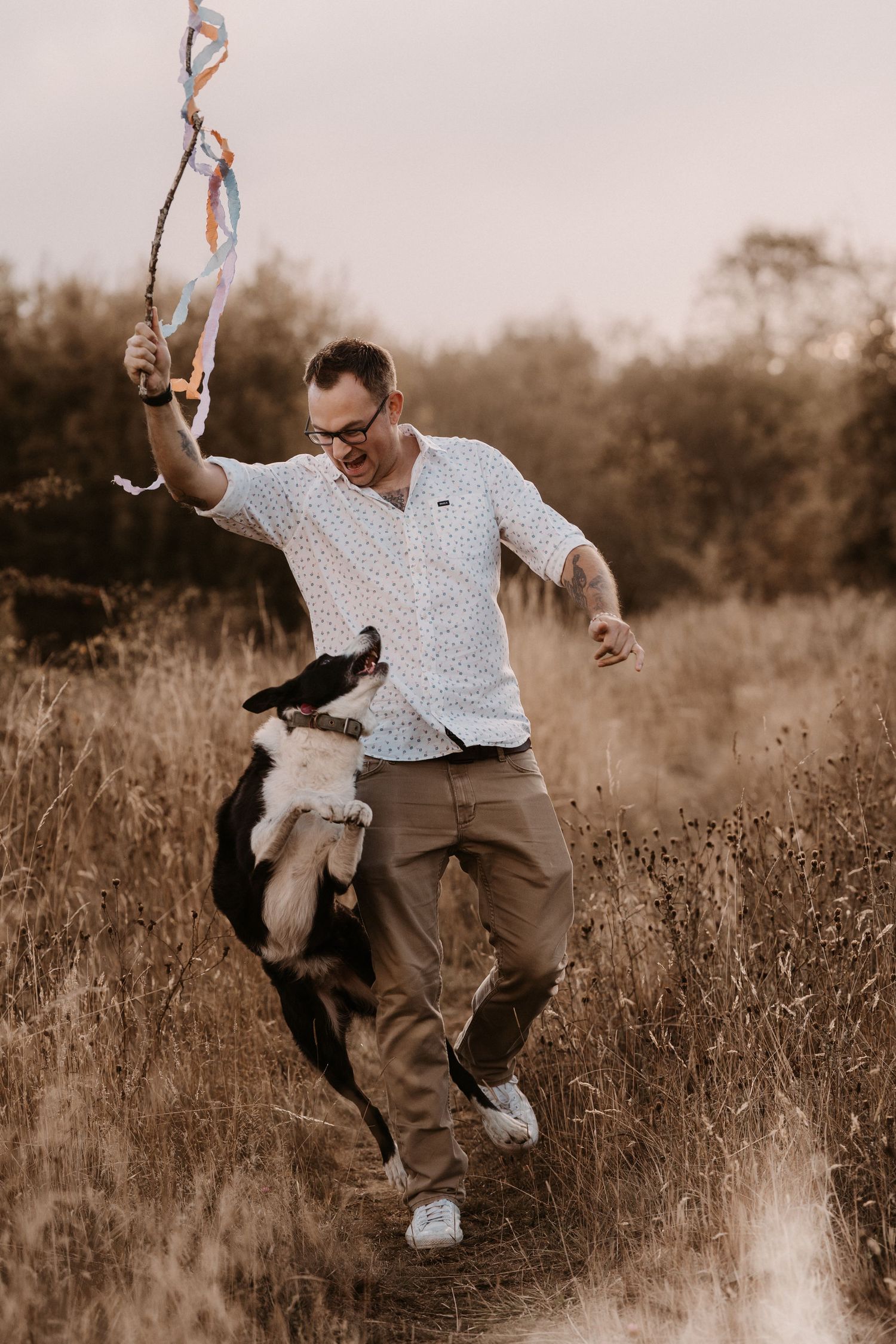 Father chasing joy with his child and dog through golden fields – authentic family photography in Burton.