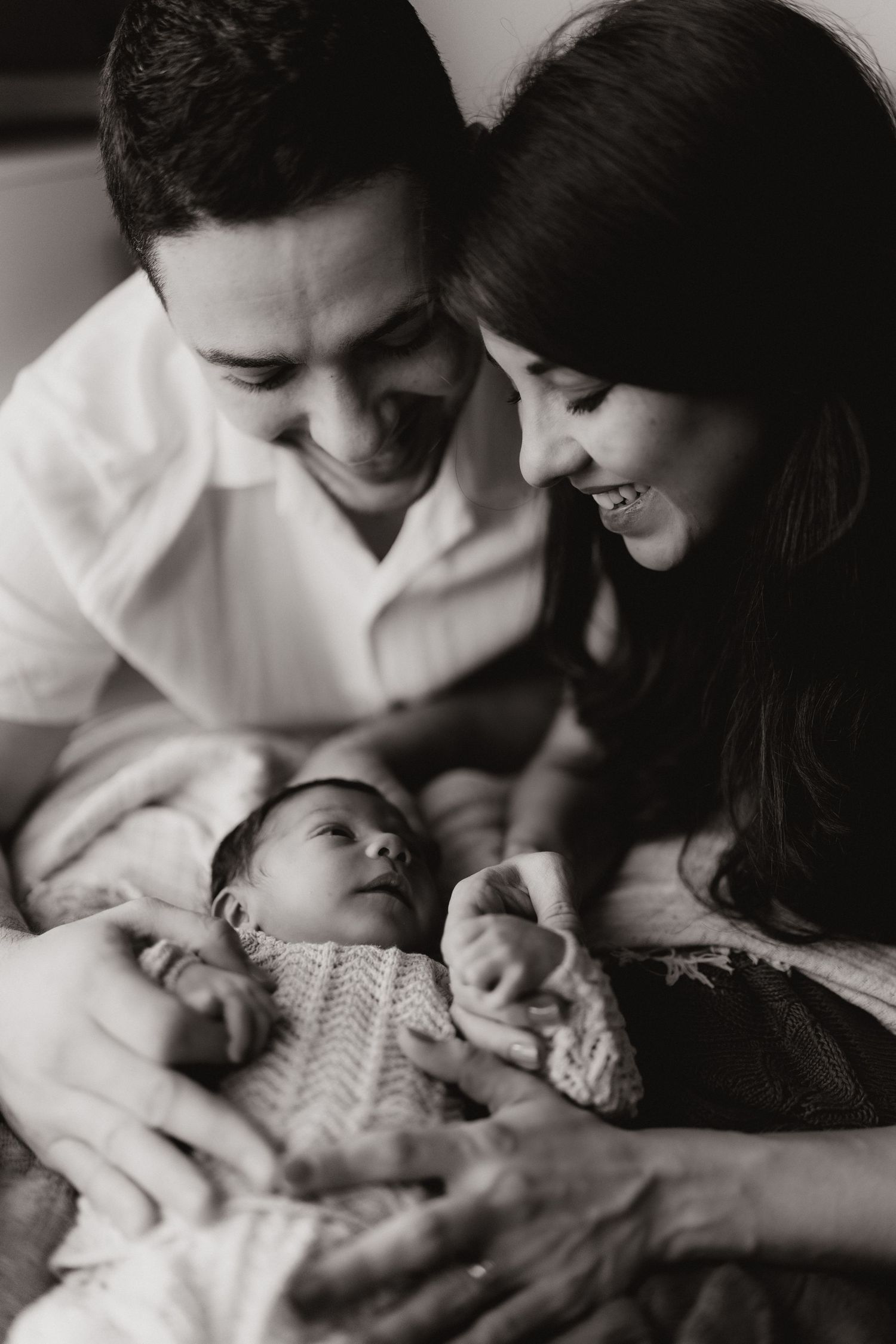 Parents gathered around their newborn during a relaxed lifestyle newborn photoshoot at home in stoke on trent