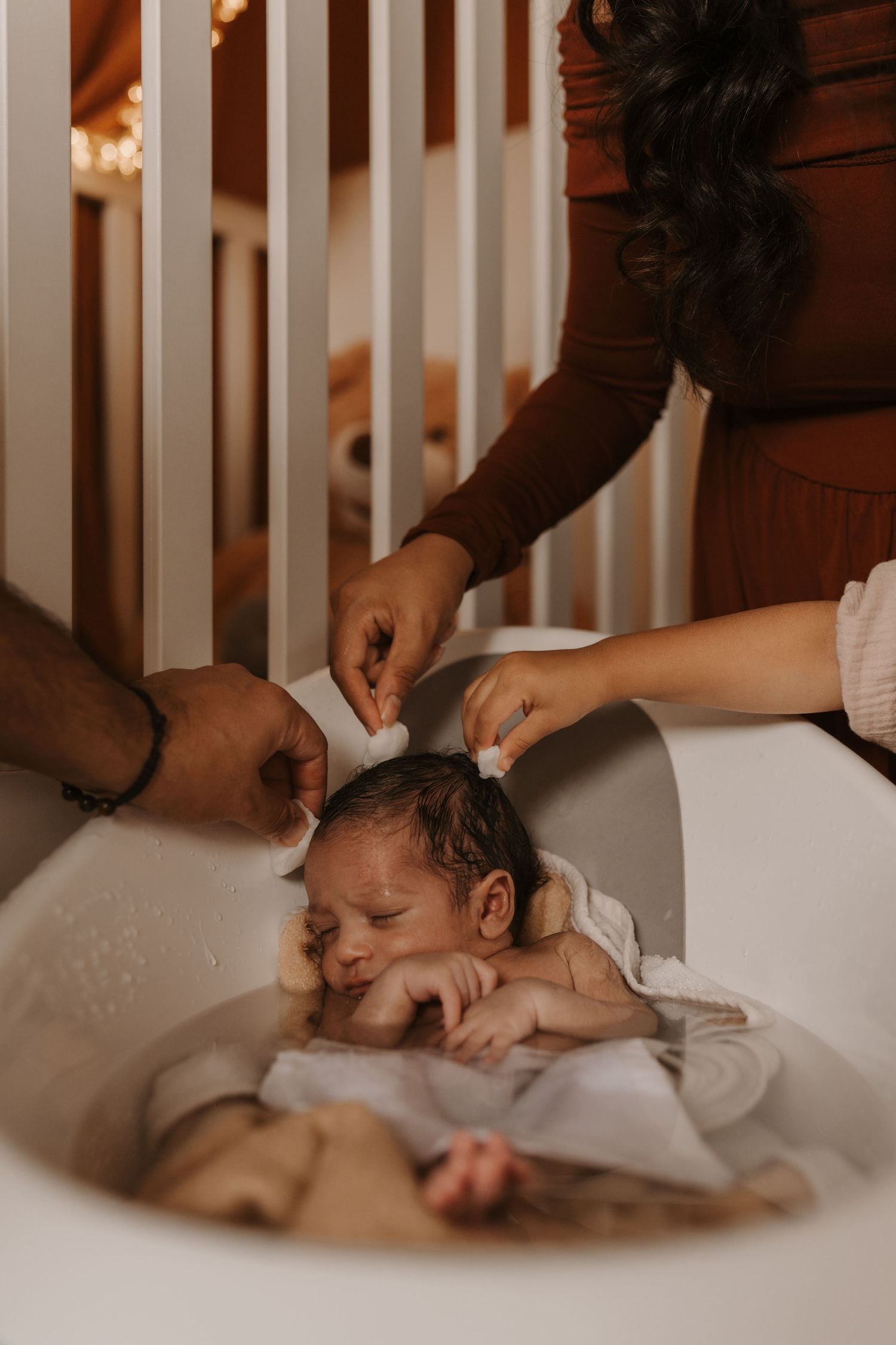 Newborn having a gentle bath at home during a relaxed lifestyle newborn photoshoot in Melbourne
