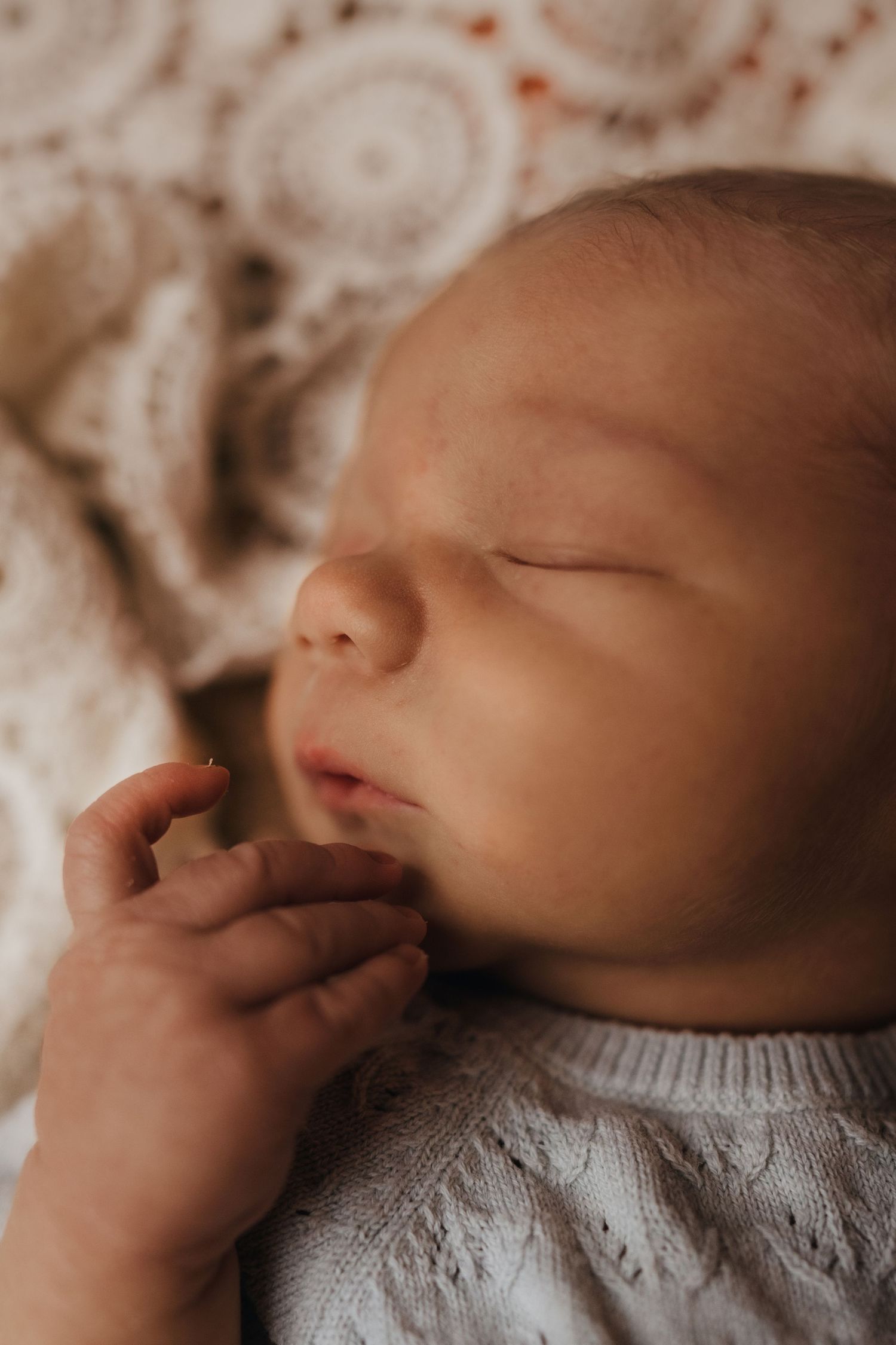 Newborn sleeping in a knitted outfit during a natural light lifestyle newborn photography session in Tamworth