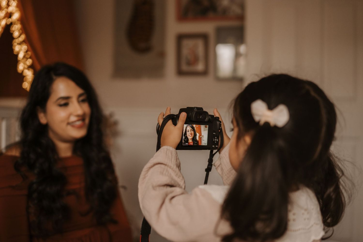 Child photographing their mother at home during a playful lifestyle family photoshoot in Melbourne