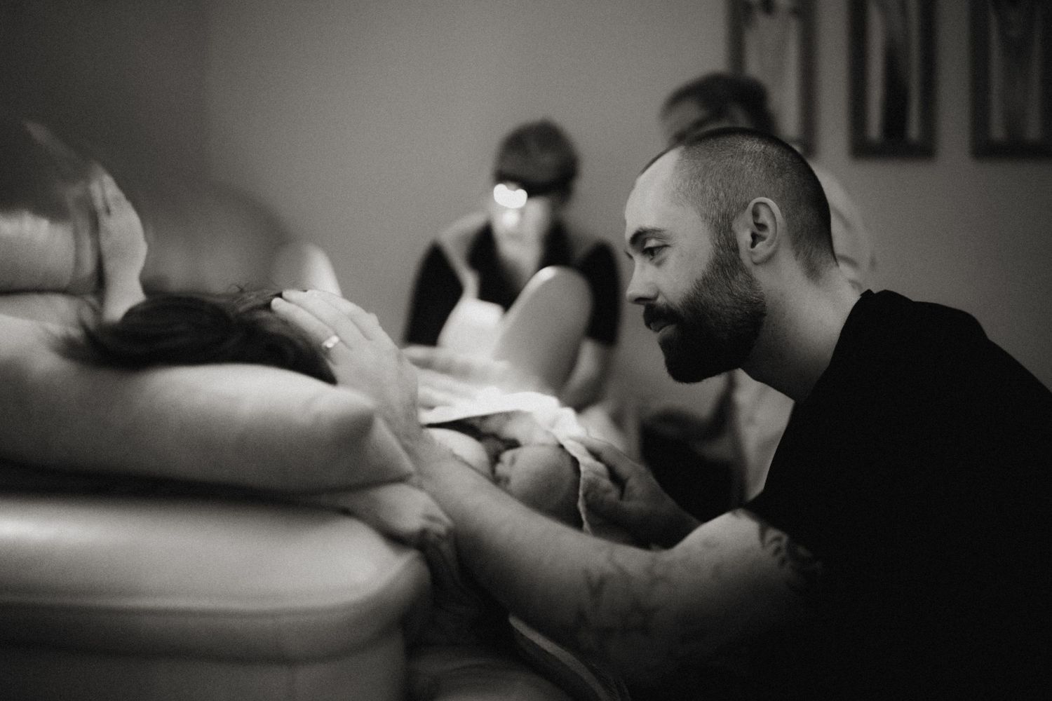 Parents holding their newborn moments after birth during an intimate documentary home birth photography session.