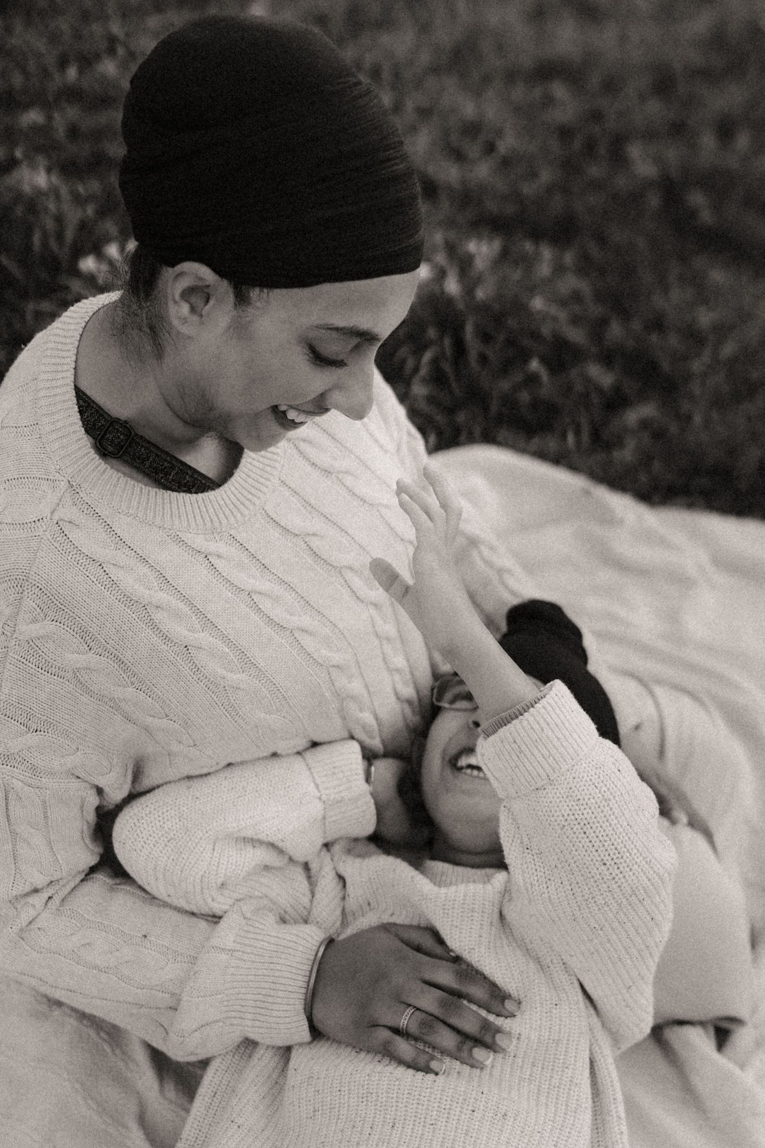 Mum sits with her son on her lap outdoors, captured during a tender motherhood photoshoot in the Midlands.