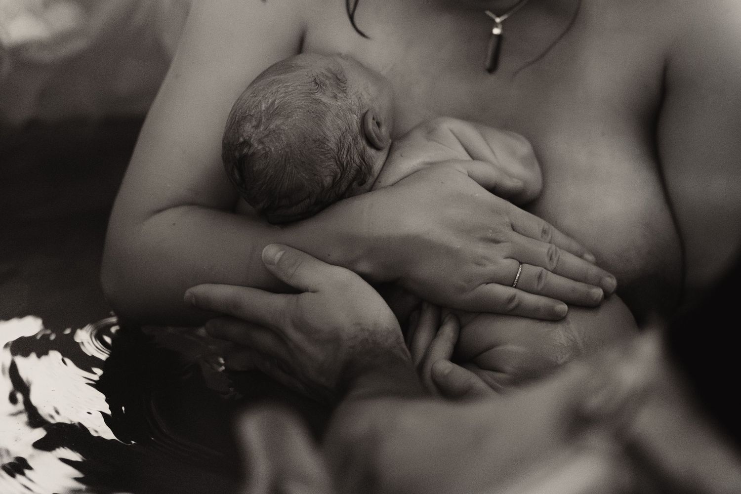 Newborn held skin-to-skin after birth during an intimate documentary birth photoshoot in Ashby de la Zouch