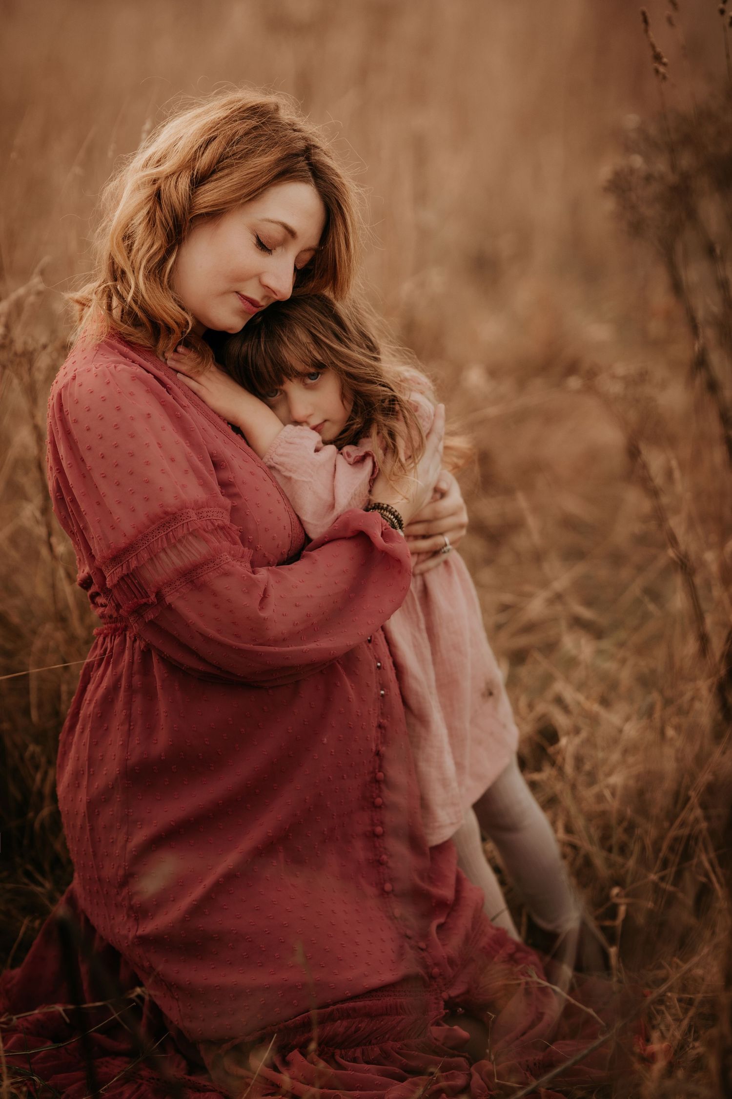 Pregnant mother hugging her daughter with gentle smile and emotions